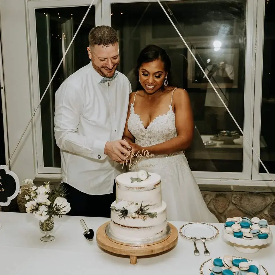 Bride wearing Flirty A-line Wedding Gown Called Savannah By Maggie Sottero Cutting The Cake with Groom