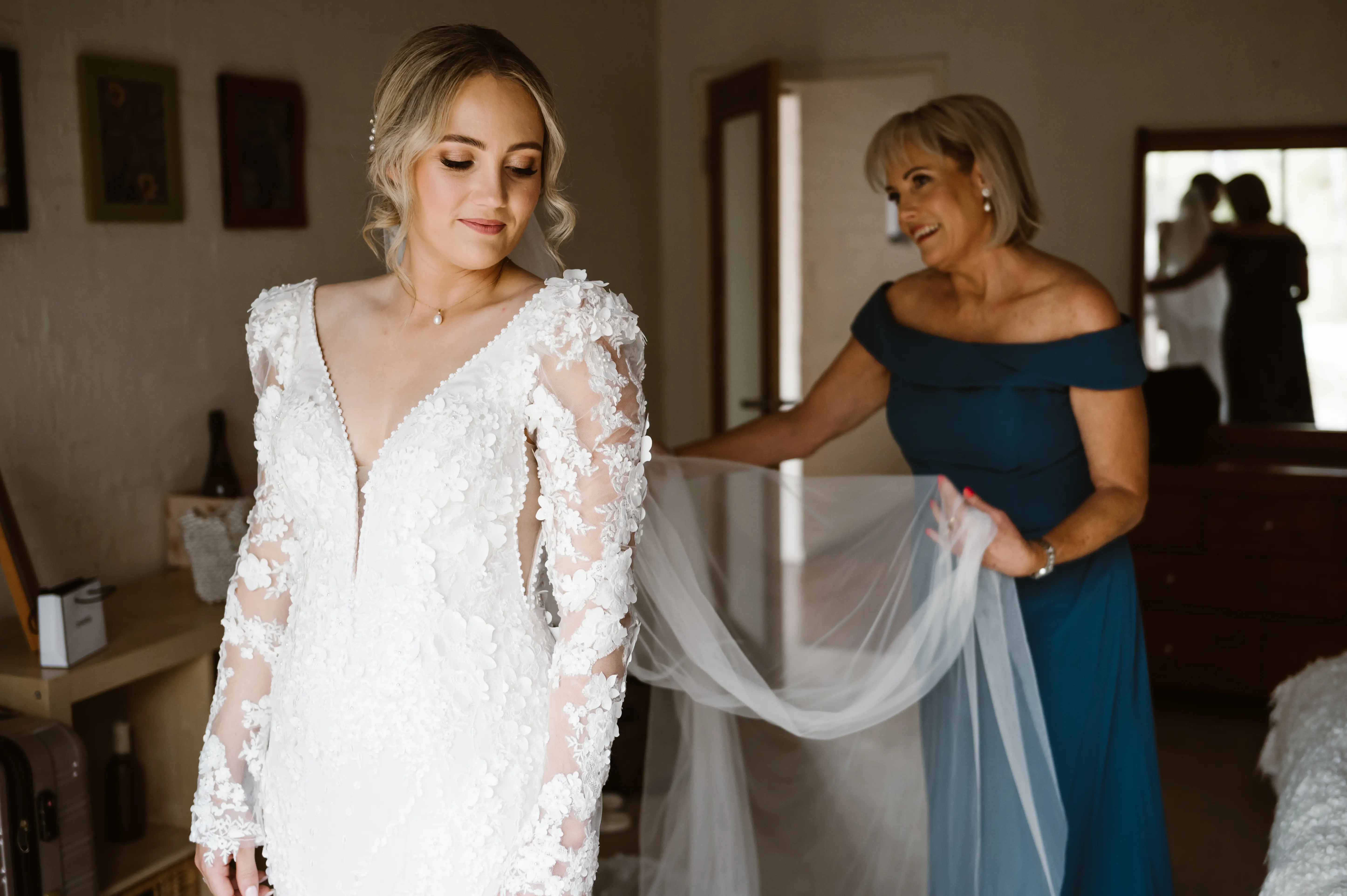 Final Touches with a Veil. Bride in Vintage Inspired Puff Sleeve Mermaid Wedding Dress in 3-D Floral Motifs Called Cruz by Sottero & Midgley