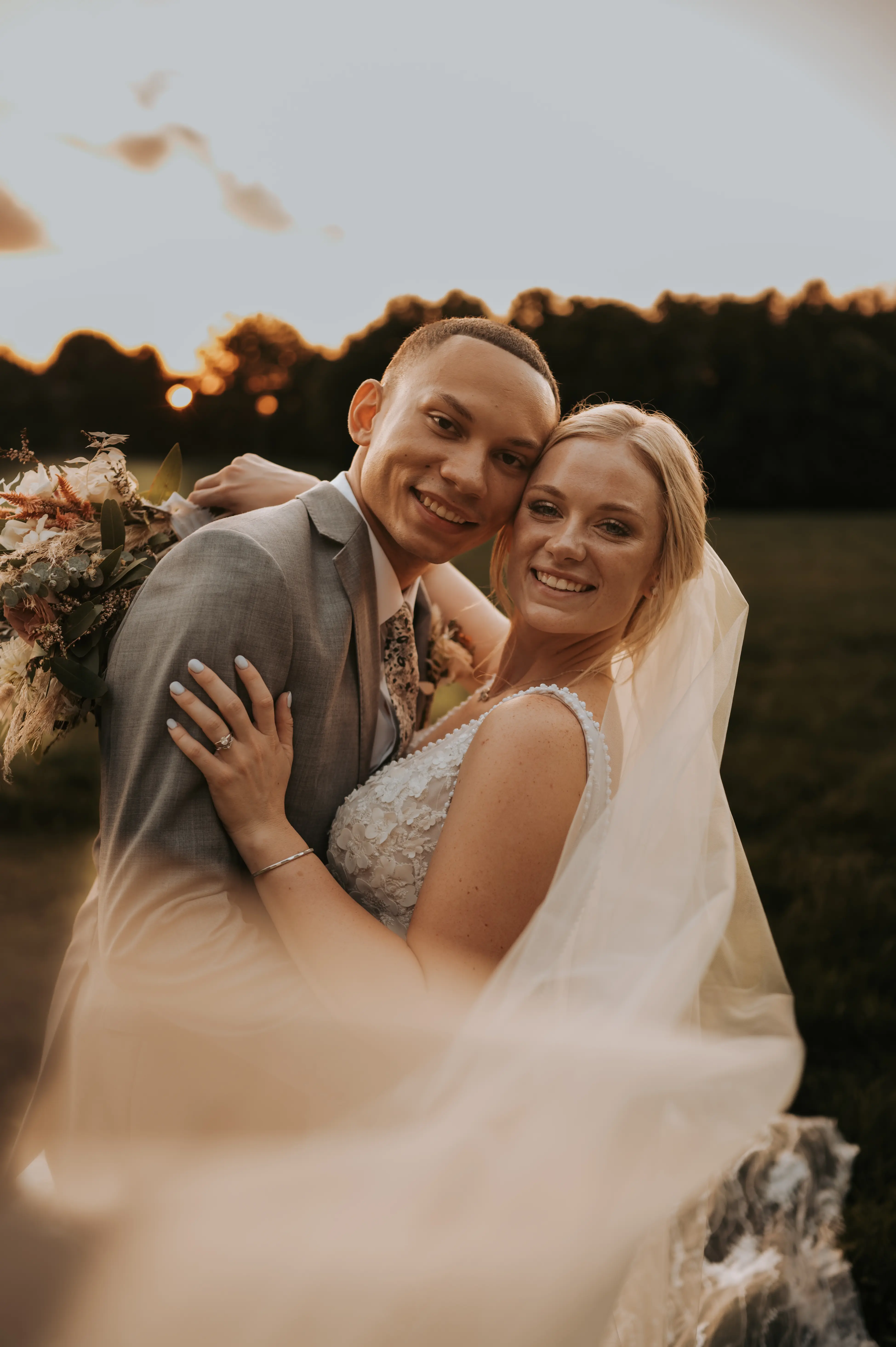 Groom with Bride in Mermaid Wedding Dress with 3-D Floral Motifs and Extended Scalloped Lace Train Called Cruz by Sottero & Midgley