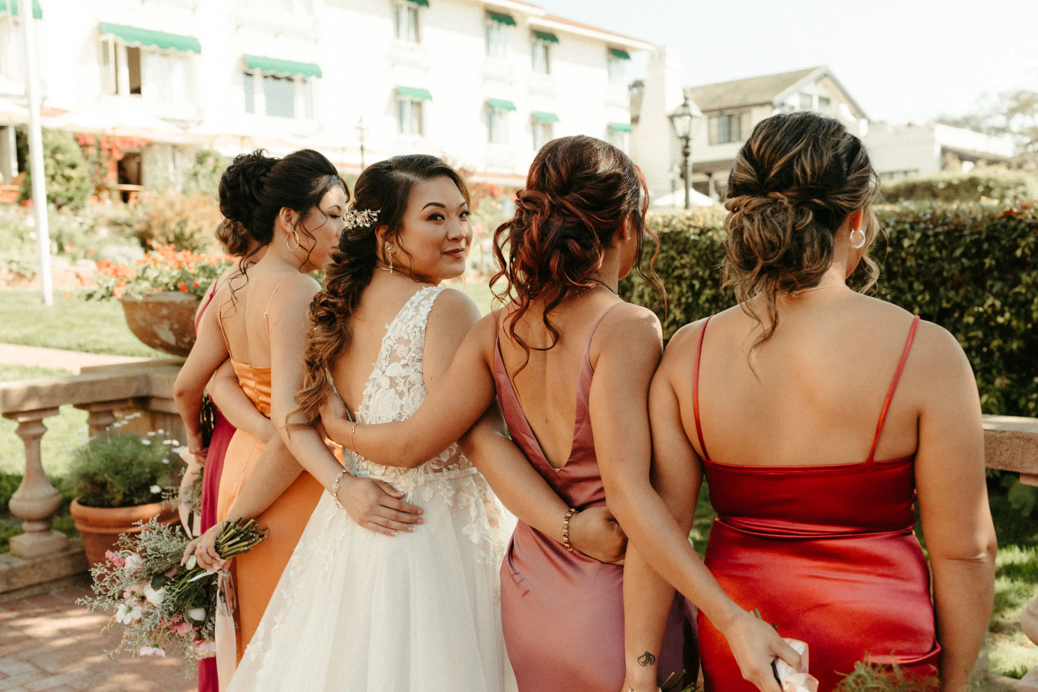 Bride with bridesmaids wearing affordable A-Line floral motif wedding dress.