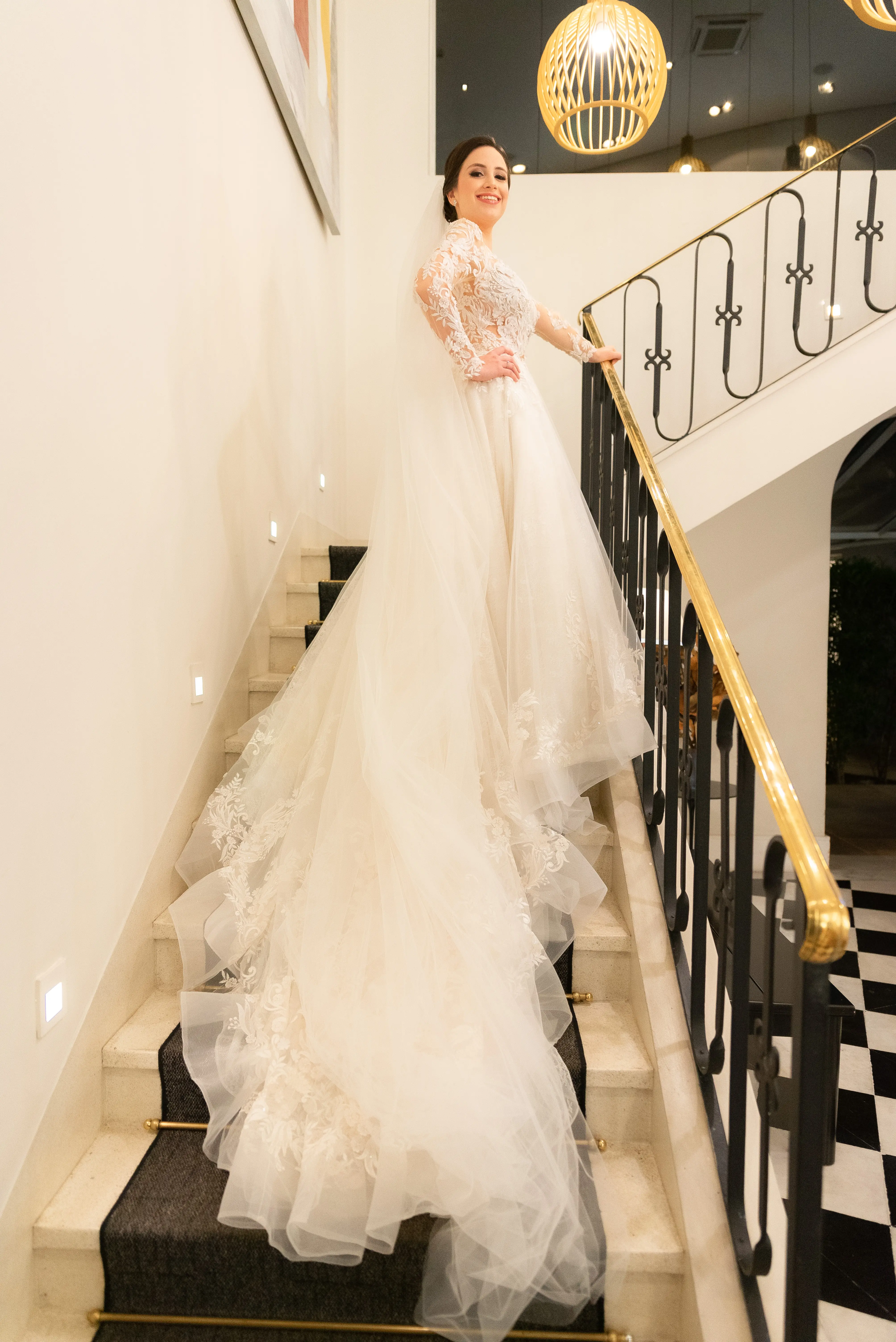 Bride Smiling While Wearing Lace A-Line Wedding Dress Called Zander By Sottero And Midgley On The Stairs
