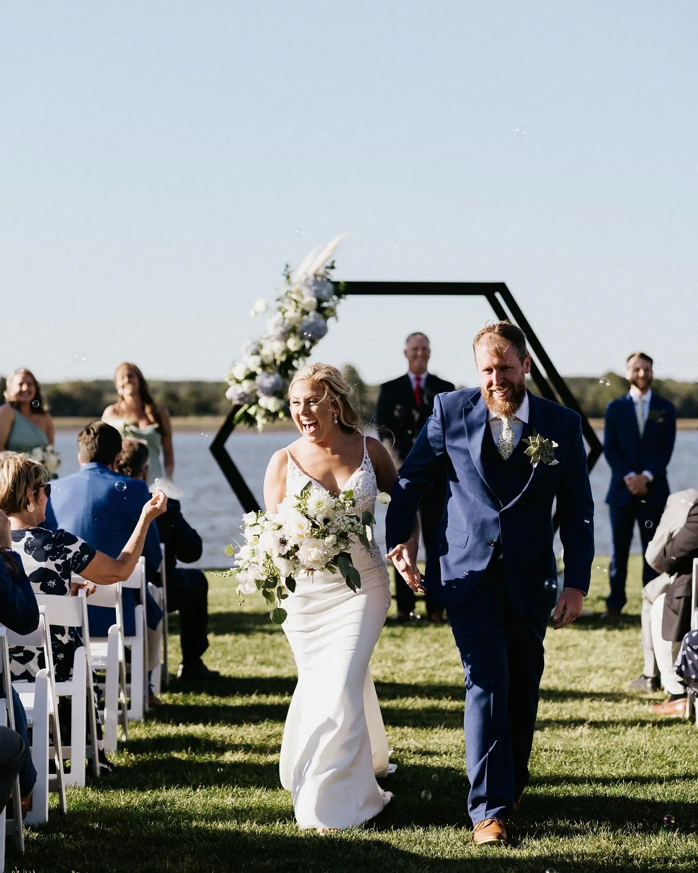 Groom Walking Up Aisle With Bride In Sleek Spaghetti Strap Wedding Dress Named Nikki By Maggie Sottero