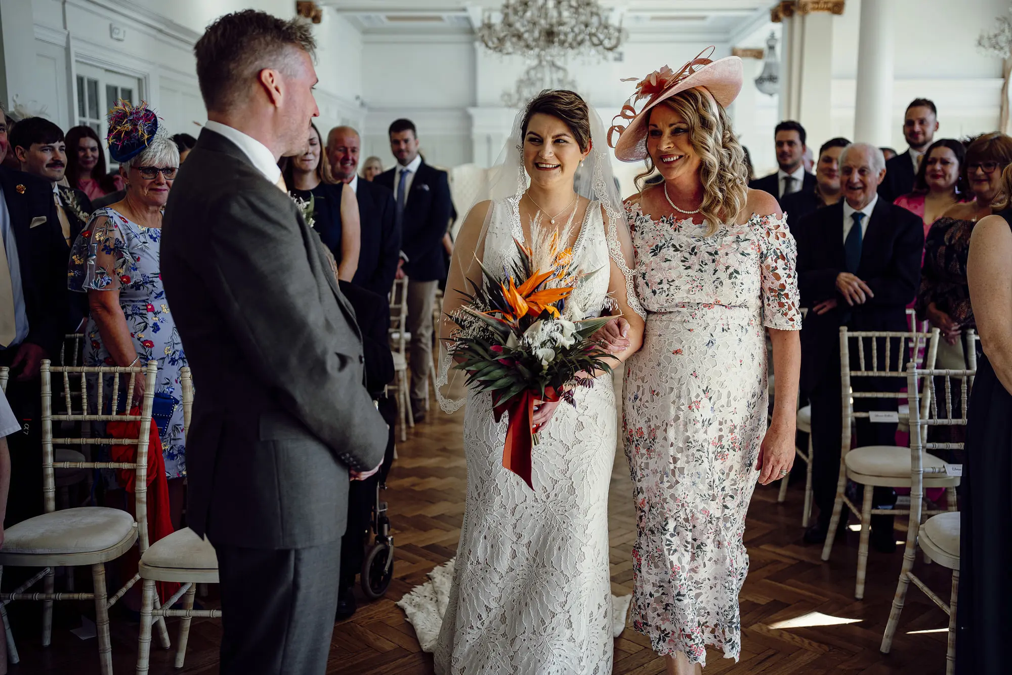 Bride Wearing Boho Lace Wedding Dress Called Burke By Maggie Sottero Walking Down The Aisle With Mother Of The Bride