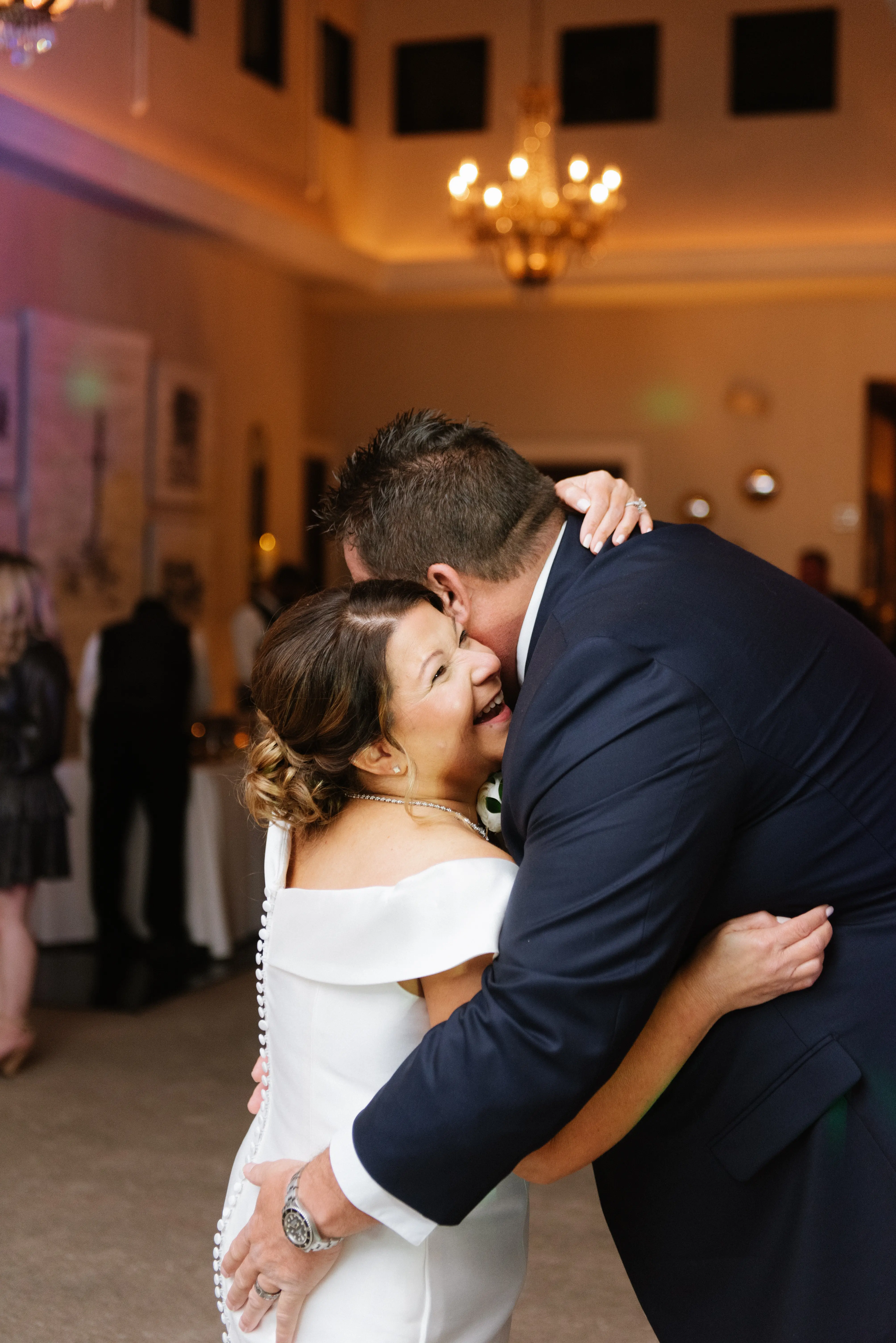 Bride with groom wearing elegant off the shoulder wedding dress