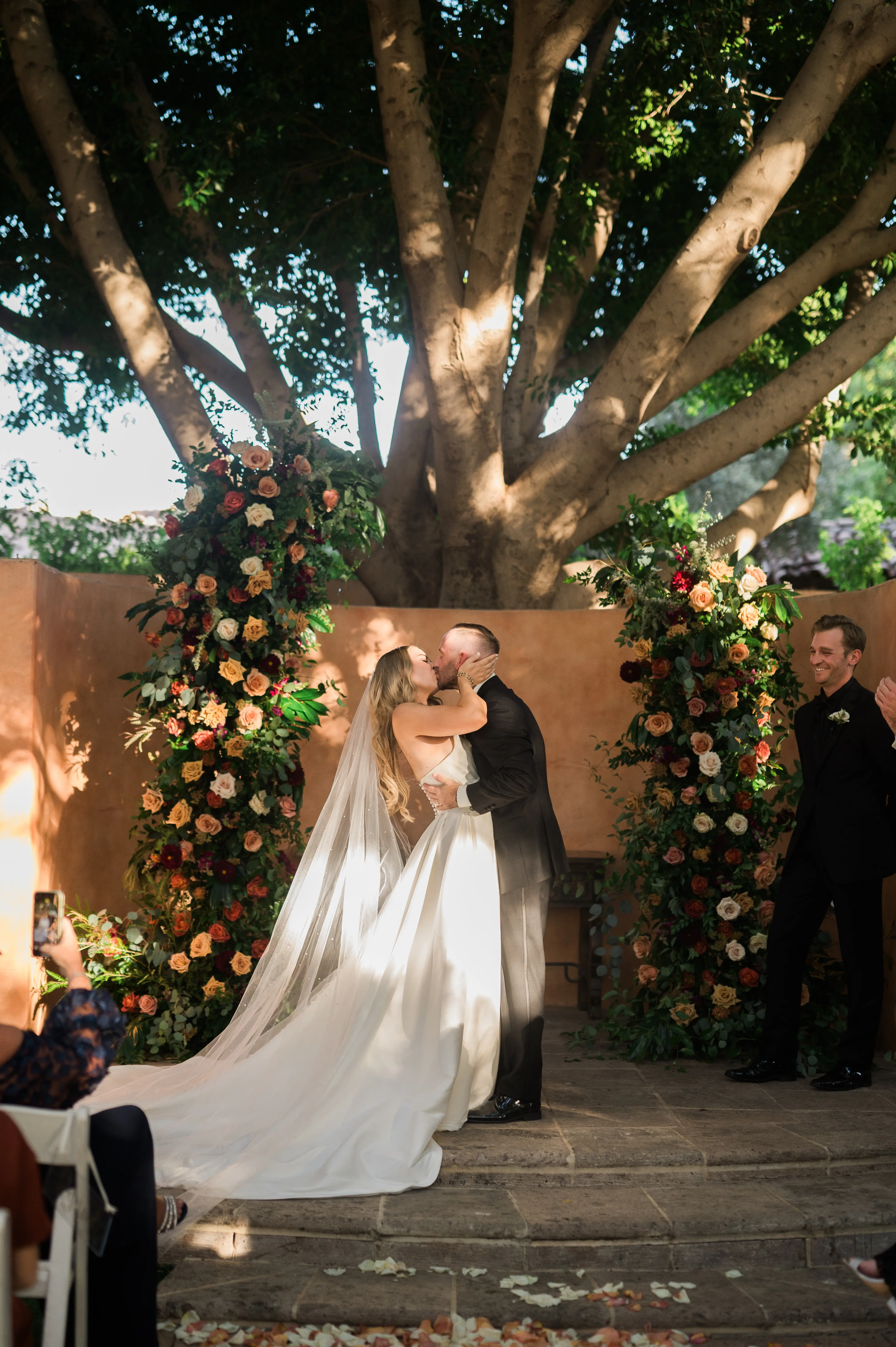 Bride wearing Aspen wedding dress by Sottero and Midgley kissing during ceremony