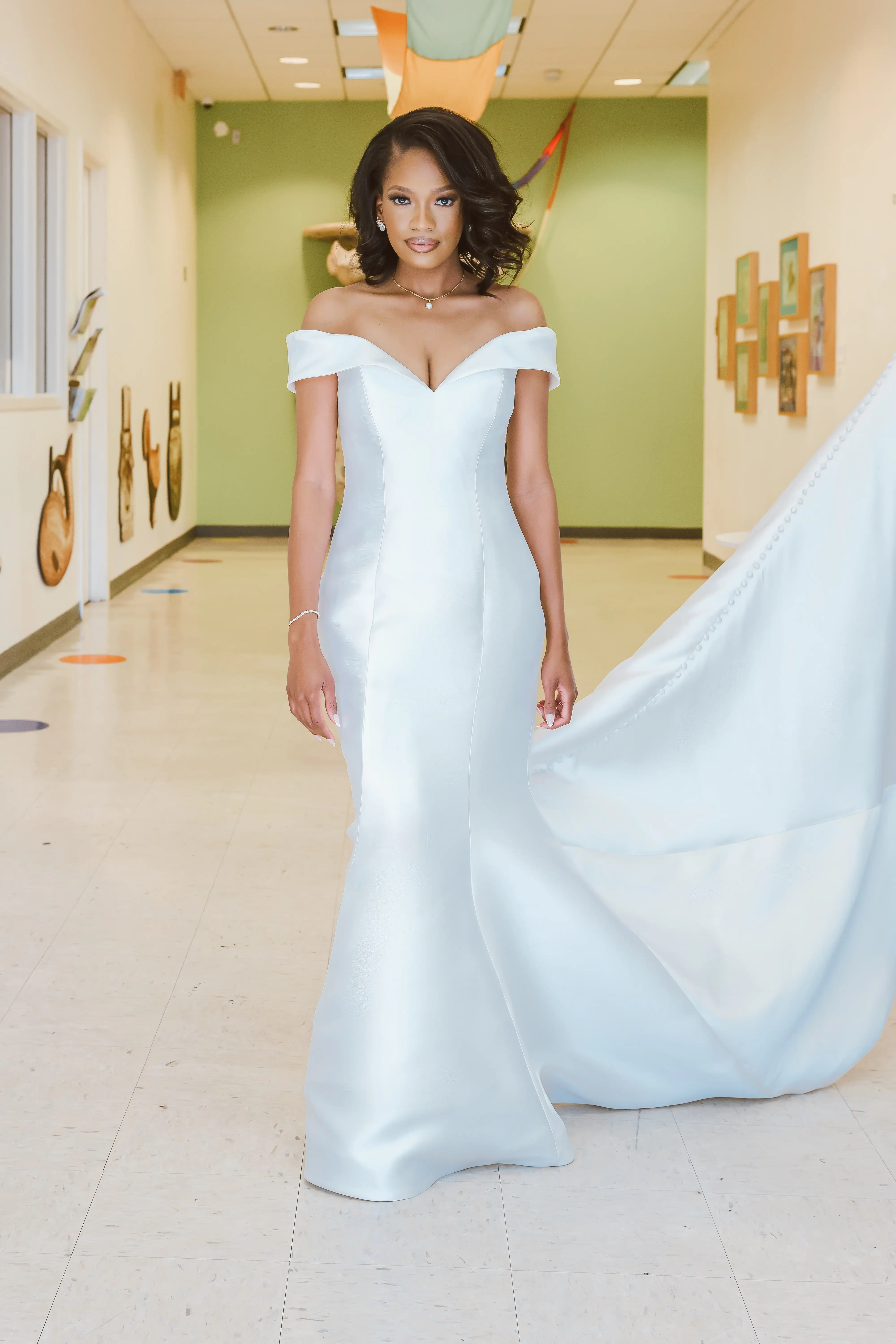 Bride Wearing Simple Mermaid Wedding Dress Called Josie By Rebecca Ingram Walking Through A Hallway