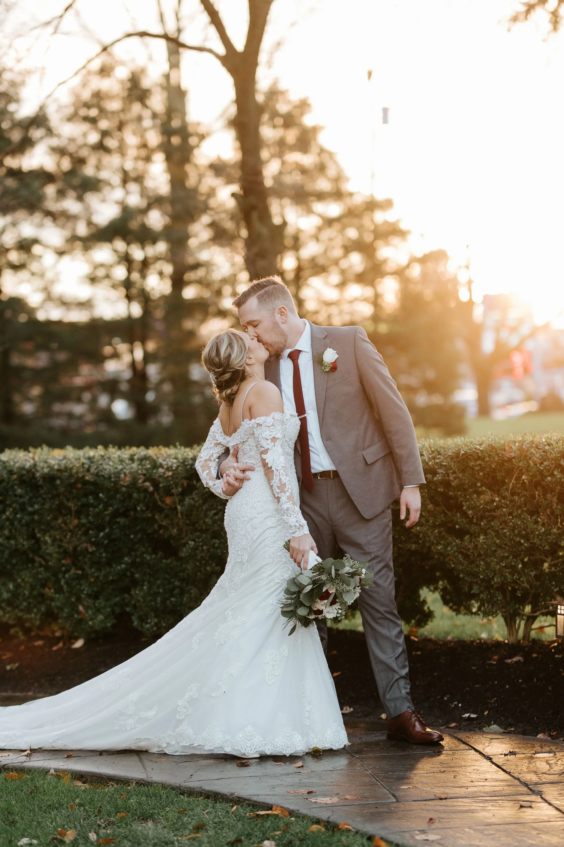 Groom Kissing Bride in Sparkly Lace Fit-and-Flare Bridal Dress with Off-the-Shoulder Sleeves Called Fiona by Maggie Sottero