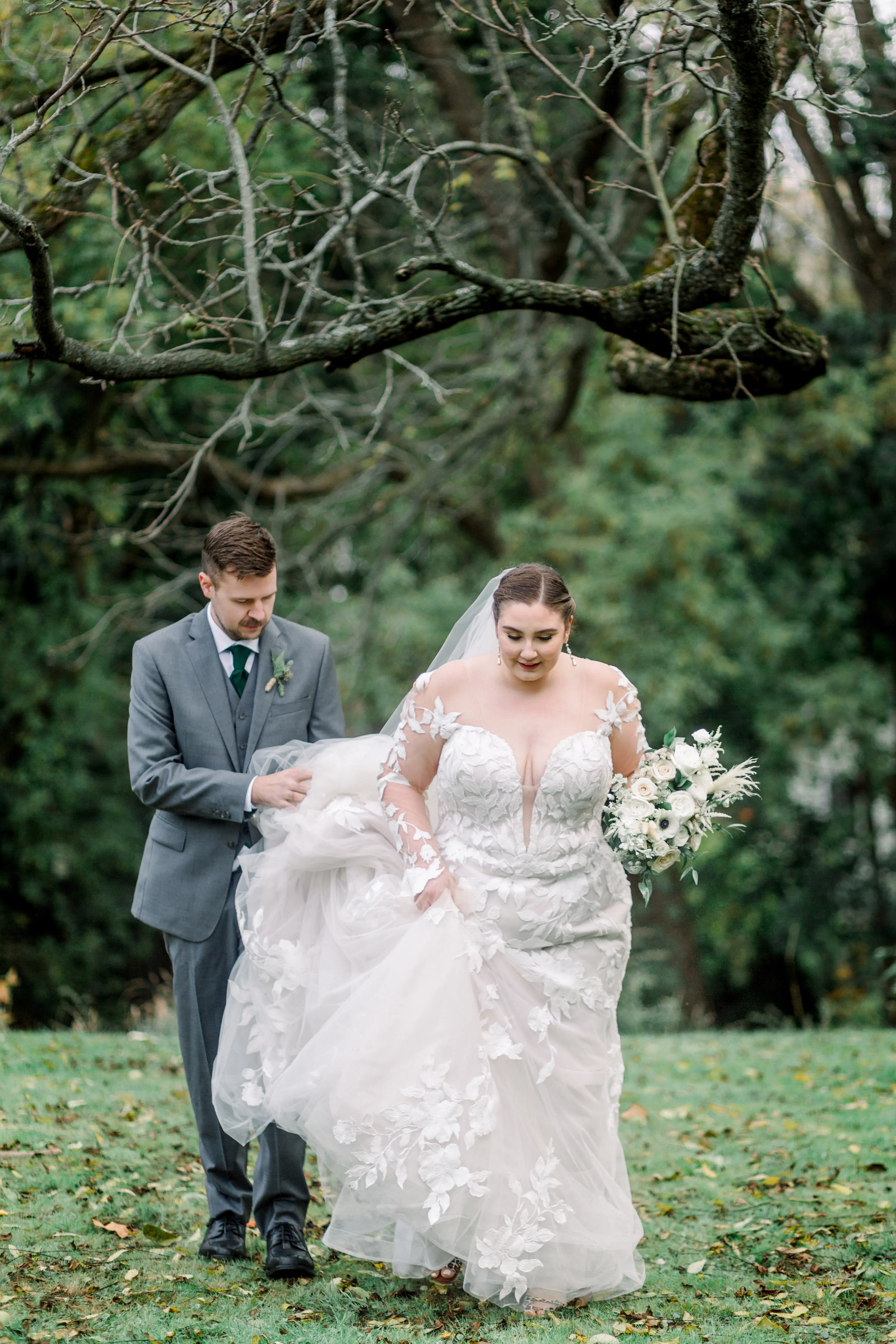 Bride wearing Hattie by Rebecca Ingram with her husband holding her train