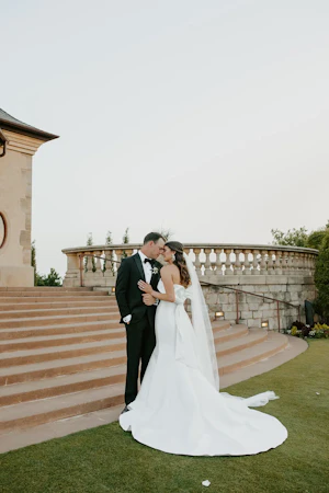 Groom With Bride Wearing Strapless Wedding Dress Featuring Big Bow Mitchell By Maggie Sottero