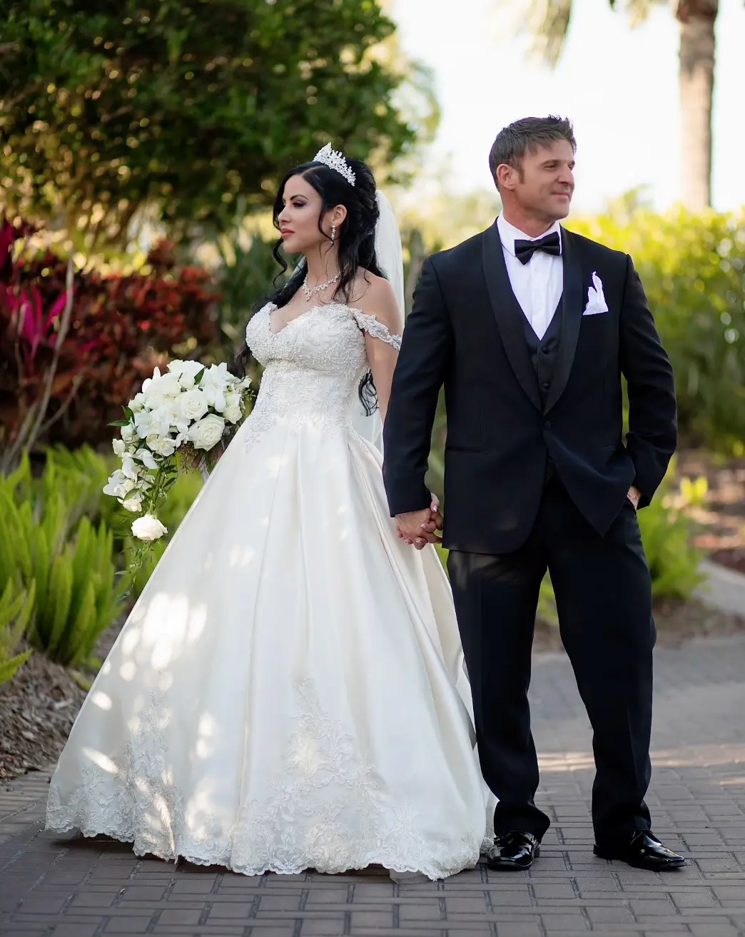 Bride wearing elegant satin ballgown called Kimora by Sottero and Midgley with groom