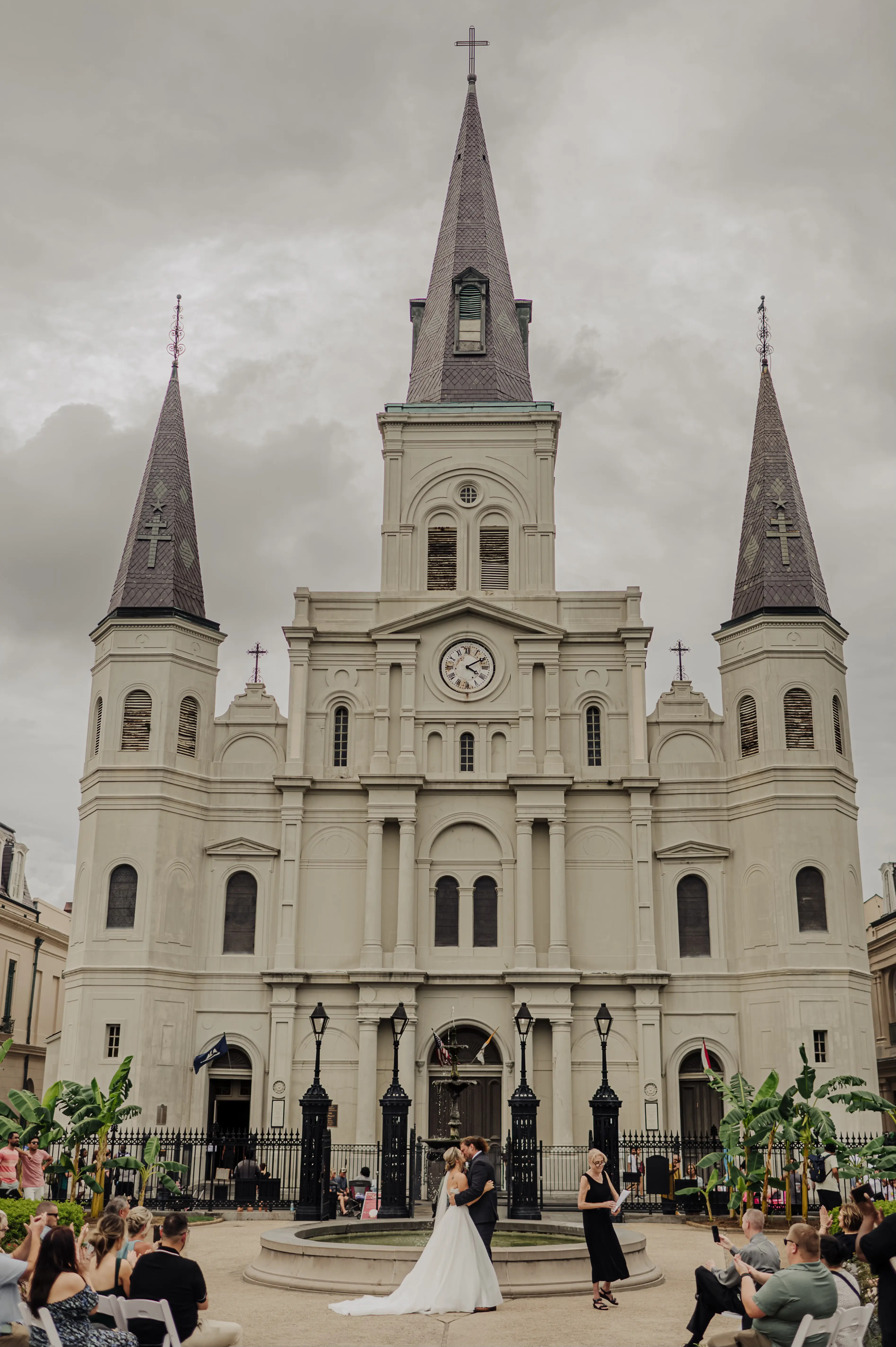 Bride Wearing Modern Princess Wedding Dress Called Aubrielle By Maggie Sottero Kissing Groom With New Orleans Cathedral Behind Them