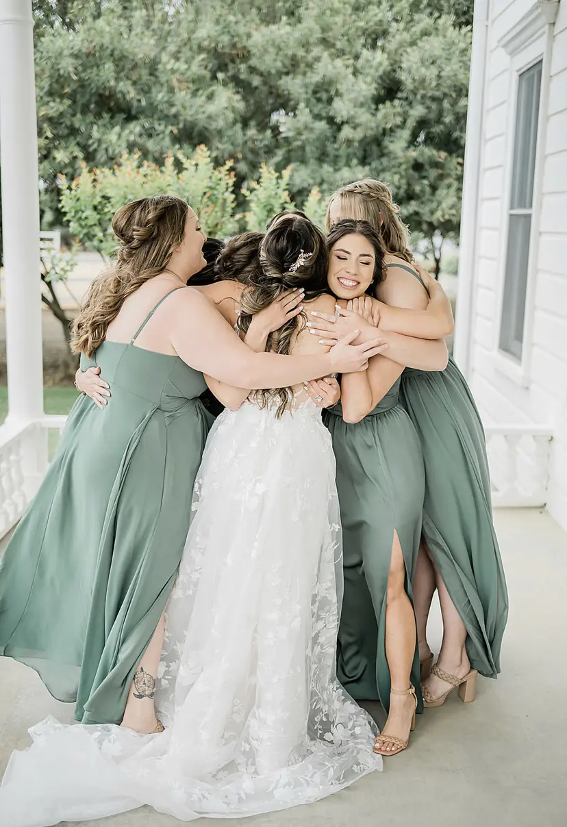 Bridesmaids Hug Bride Wearing Floral Whimsical Wedding Gown Winter by Maggie Sottero