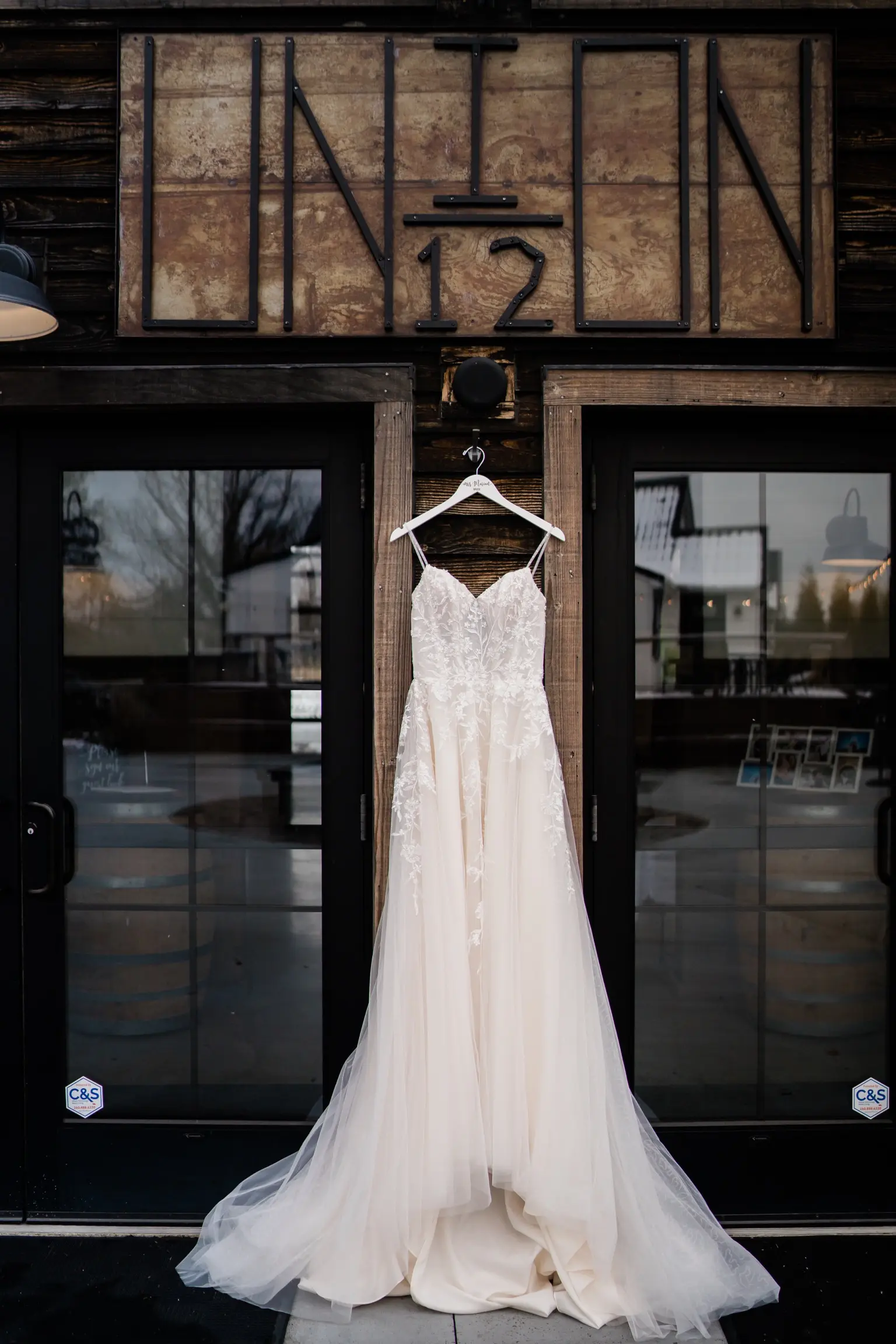 Ballerina-inspired Romantic Wedding Dress Called Fairbanks By Maggie Sottero Hanging From A Window