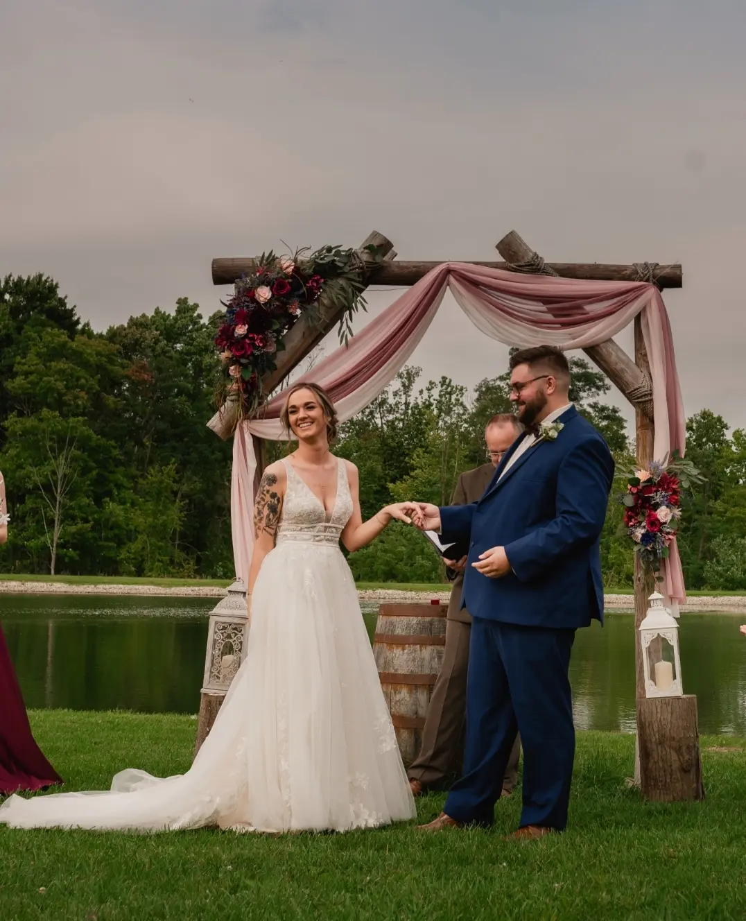 Bride wearing Boho Lace Wedding Dress called Raelynn by Rebecca Ingram with the groom at the altar