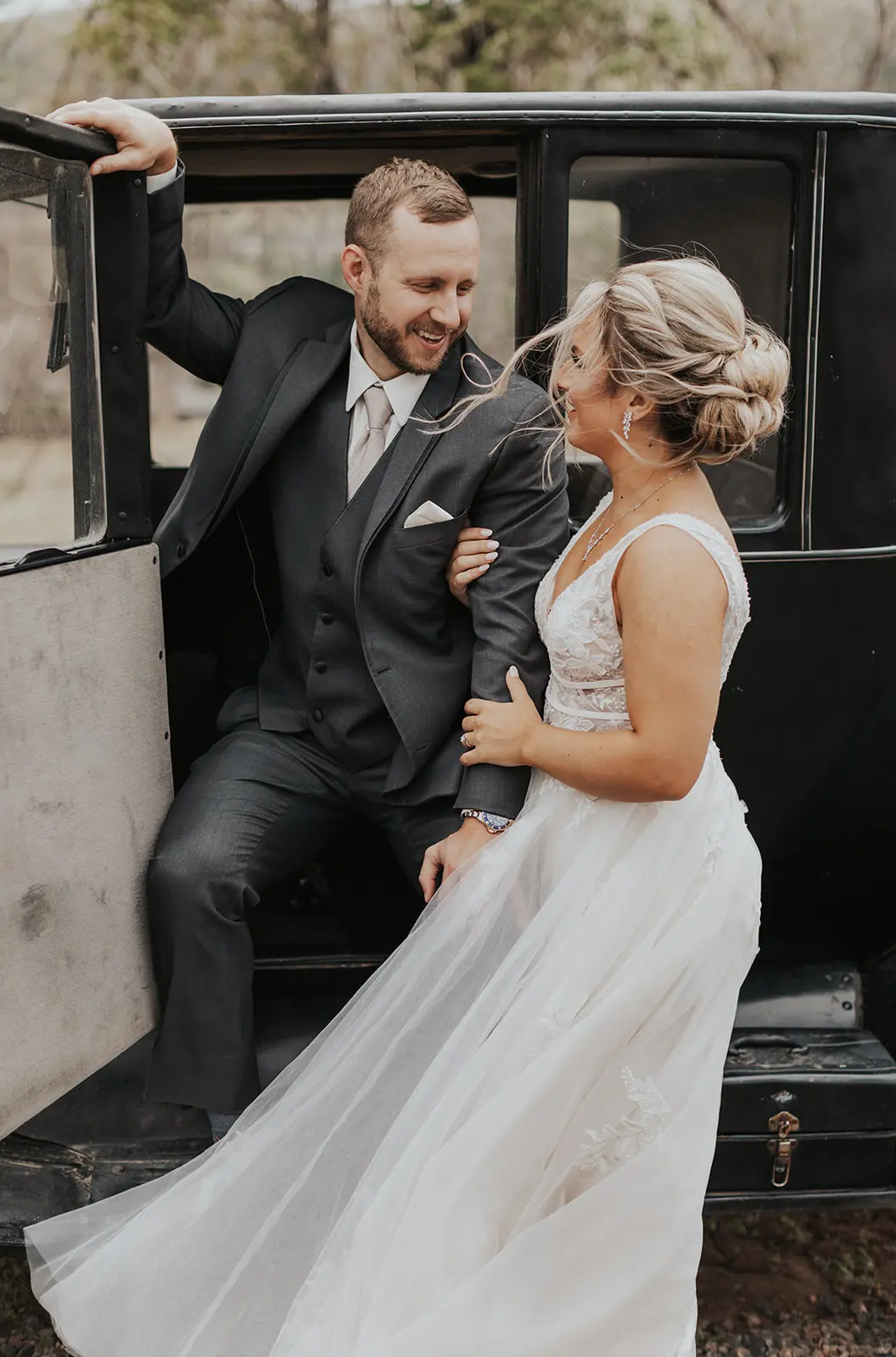 Bride In Lace Backless Wedding Dress Called Raelynn By Rebecca Ingram With Groom In Vintage Car