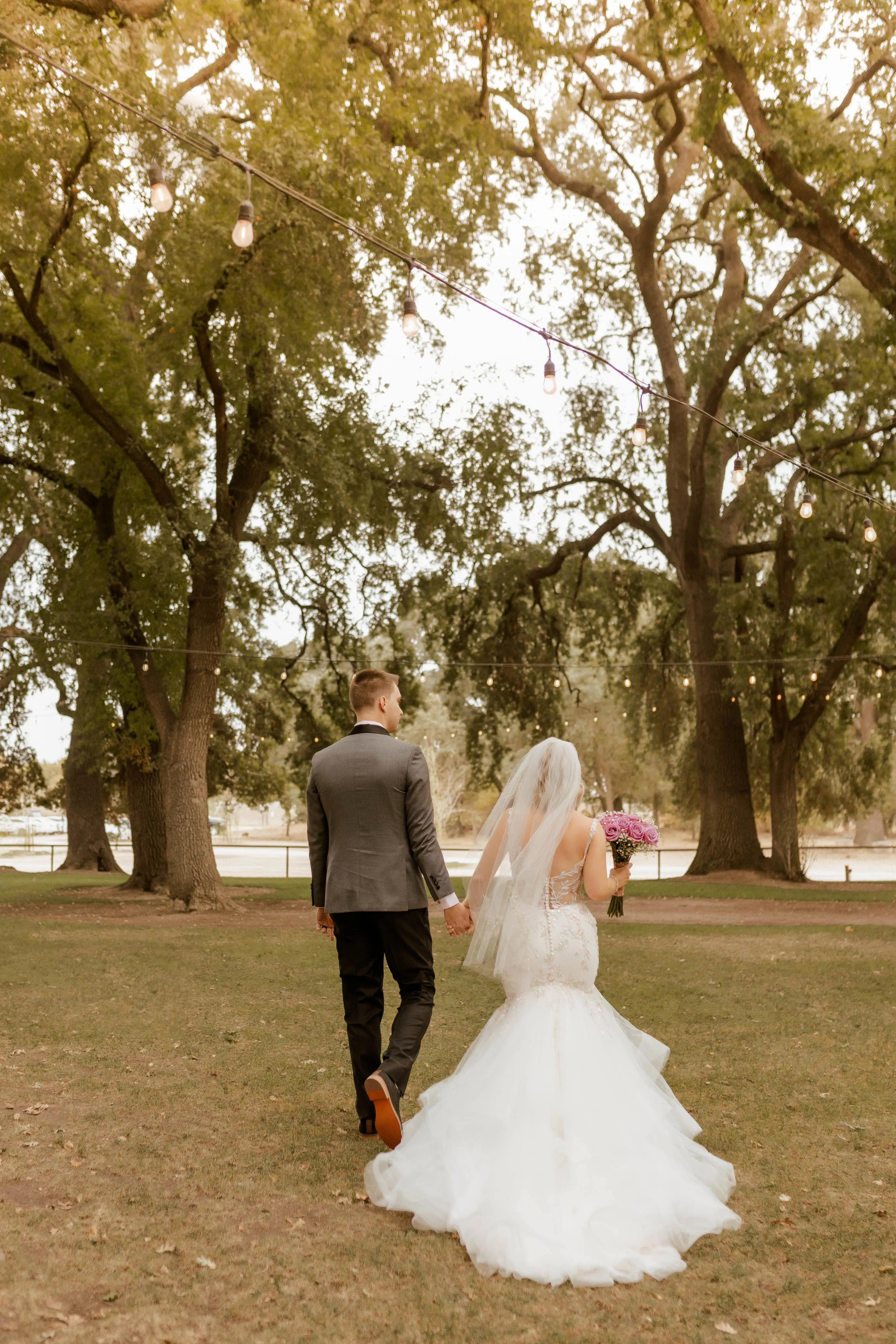 Bride Wearing Pink Lace Mermaid Wedding Dress Called Kenleigh By Sottero And Midgley Walking With Groom
