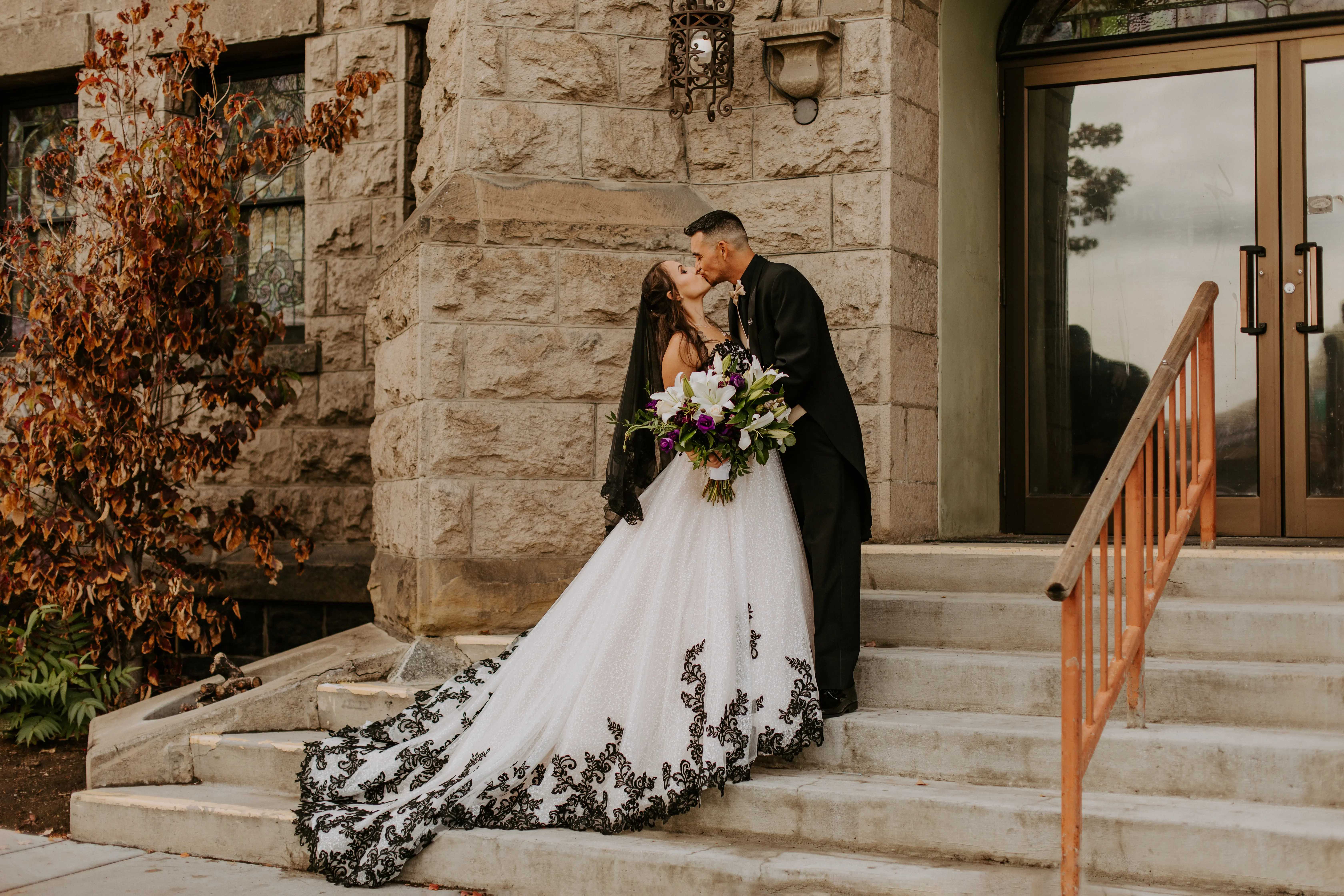 Bride wearing Black Lace Ballgown Wedding Dress called Tristyn by Maggie Sottero kissing the groom
