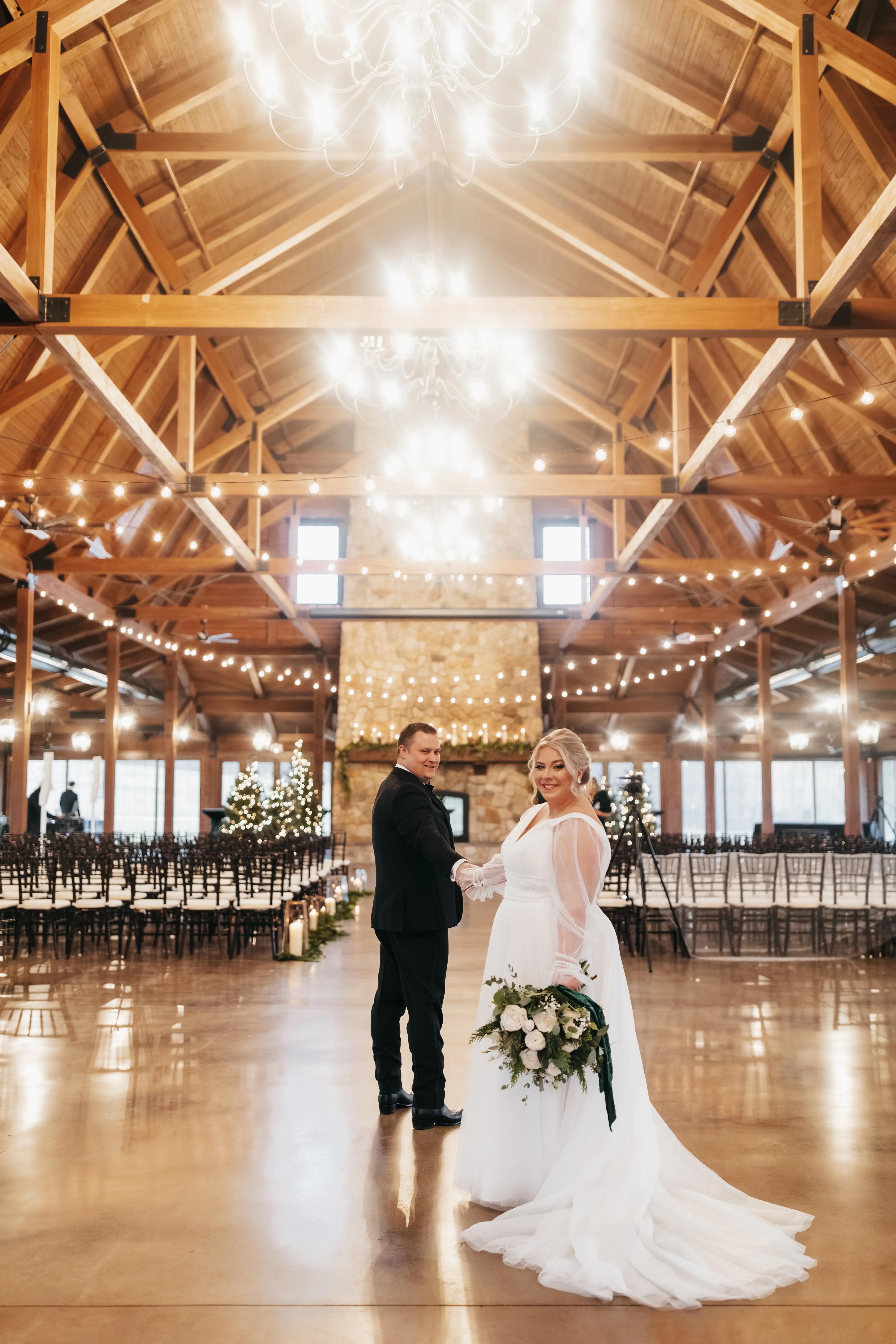 Bride wearing Joanne wedding dress by Rebecca Ingram holding hands with her husband