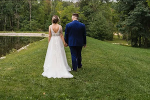Bride wearing Boho Lace Wedding Dress called Raelynn by Rebecca Ingram walking with the groom