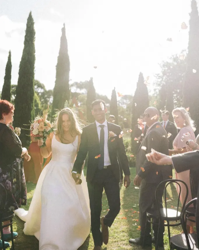Bride in Mikado Ball Down Wedding Dress Selena by Maggie Sottero Walking Down the Isle with Groom
