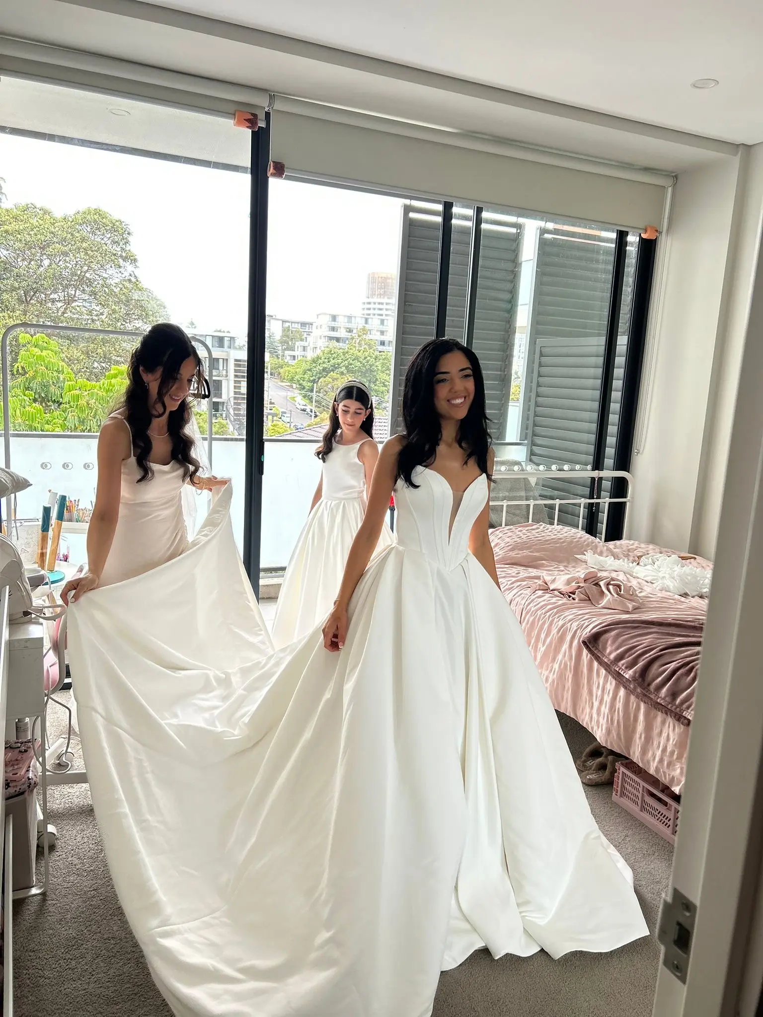 Bride wearing Derrick by Maggie Sottero getting ready with her bridesmaids