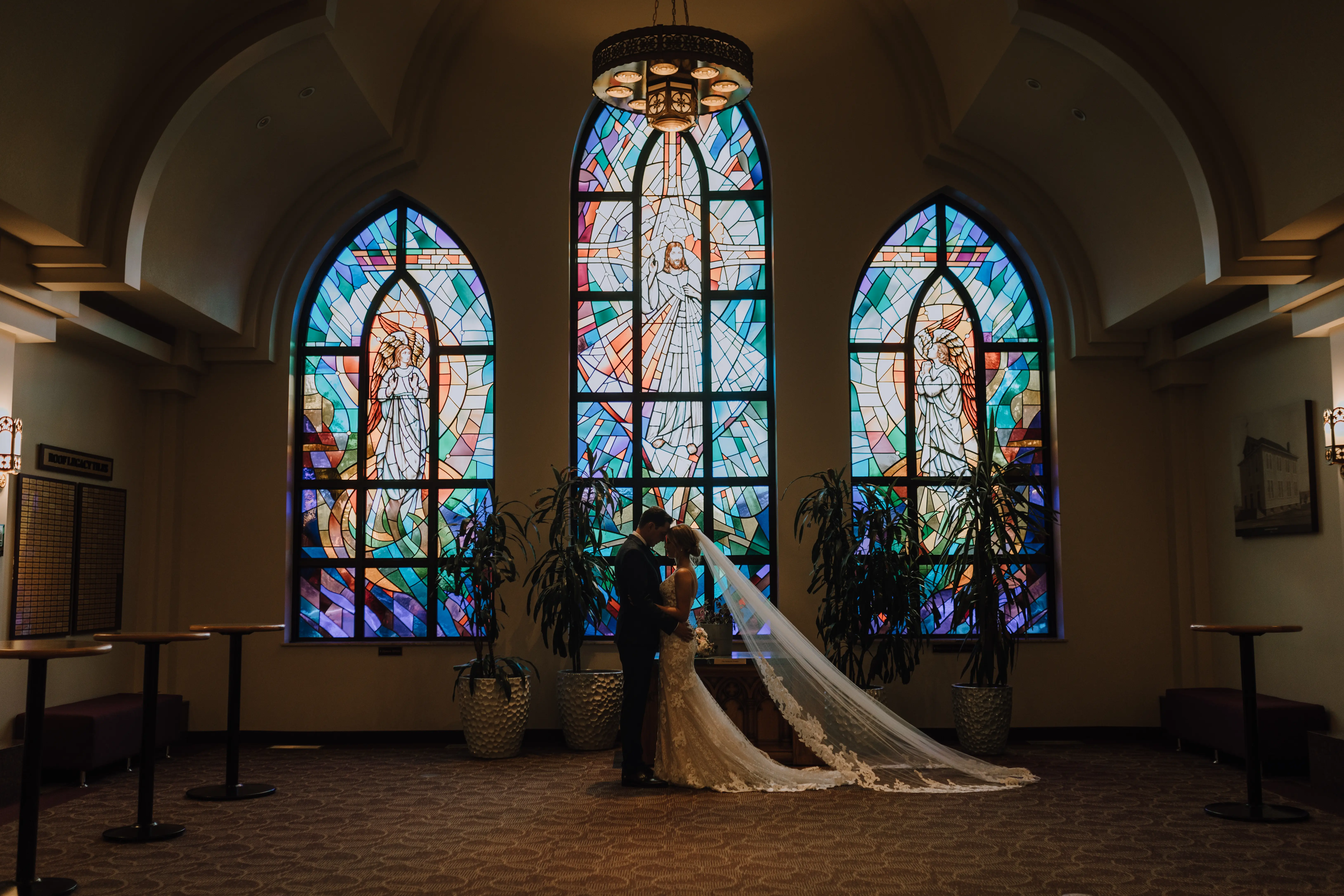 Bride with groom wearing a romantic lace sheath wedding dress.