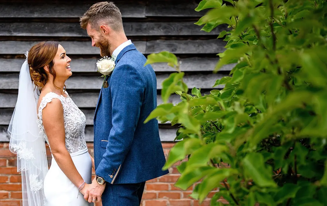 Newlyweds looking at each other holding hands.