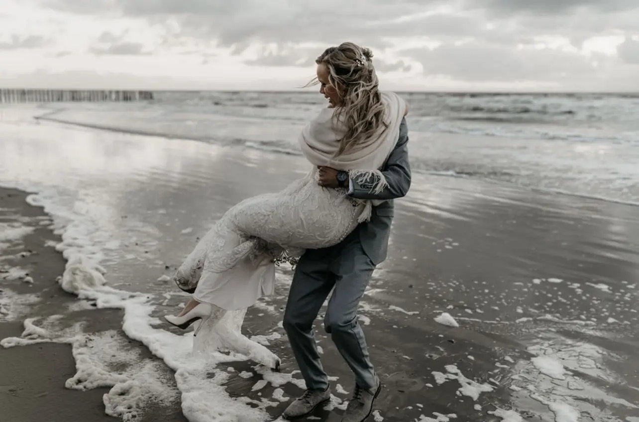 Bride Wearing Lace Fit-And-Flare Wedding Dress Called Hamilton By Sottero And Midgley With Groom Holding Her