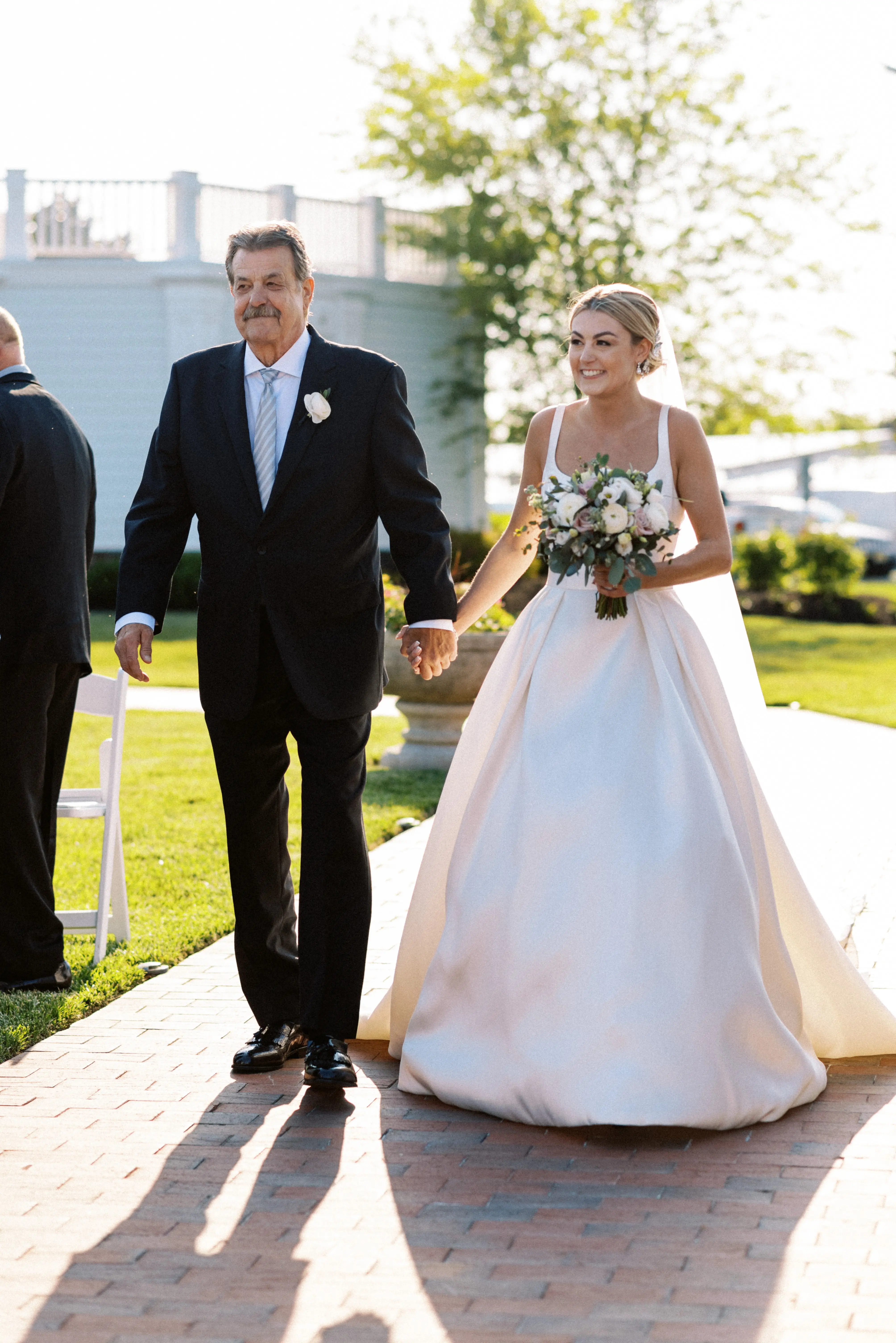 Bride wearing Selena wedding dress by Maggie Sottero walking down the aisle with her dad