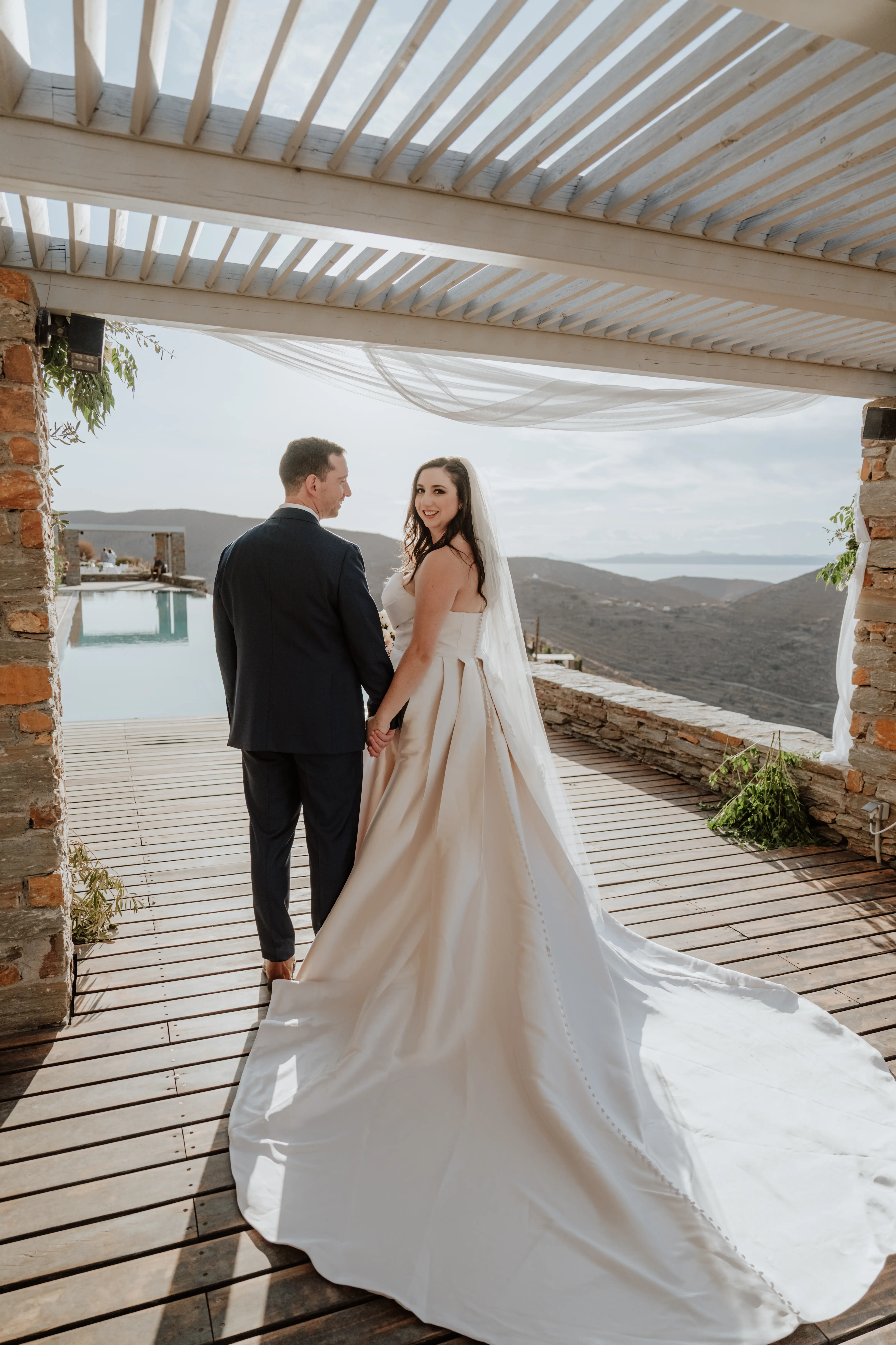 Bride wearing Aspen by Sottero and Midgley holding hands with her husband