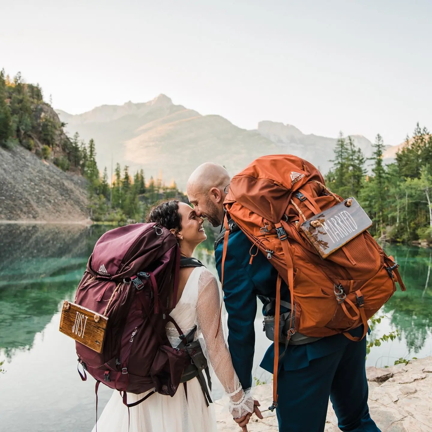 Groom with Bride Backpacking in the Mountains Wearing Vintage Boho Wedding Dress Called Joanne by Rebecca Ingram.