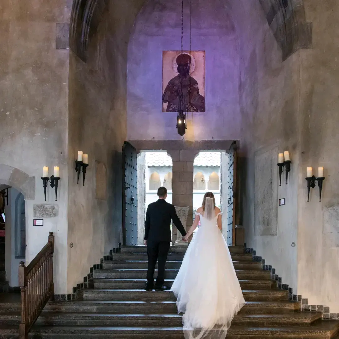 Bride wearing Harlem wedding dress by Maggie Sottero walking up stairs with her husband