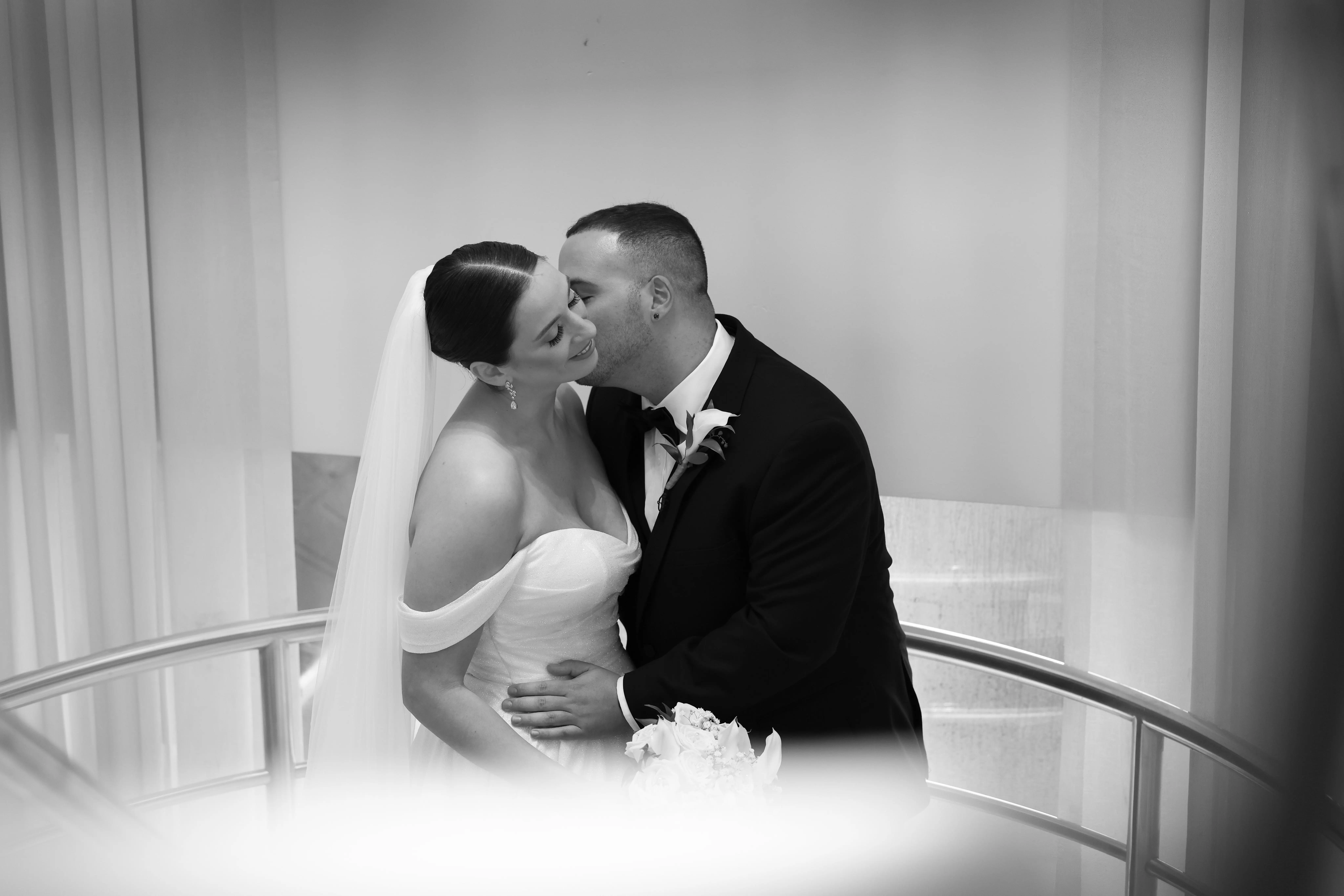 Bride wearing Anniston wedding dress by Sottero and Midgley being kissed by her husband