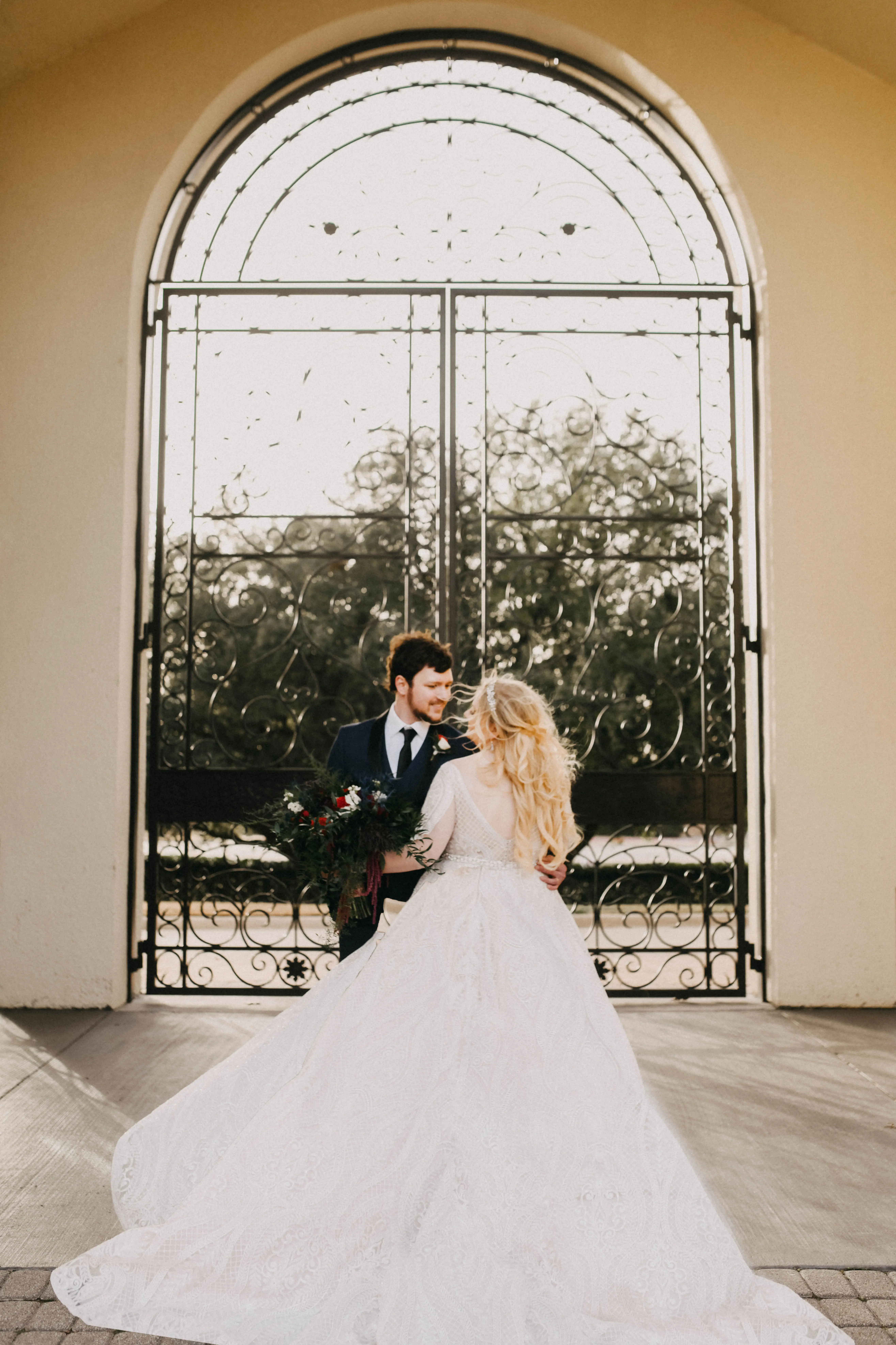 Groom looking at bride wearing dress called Roxanne.