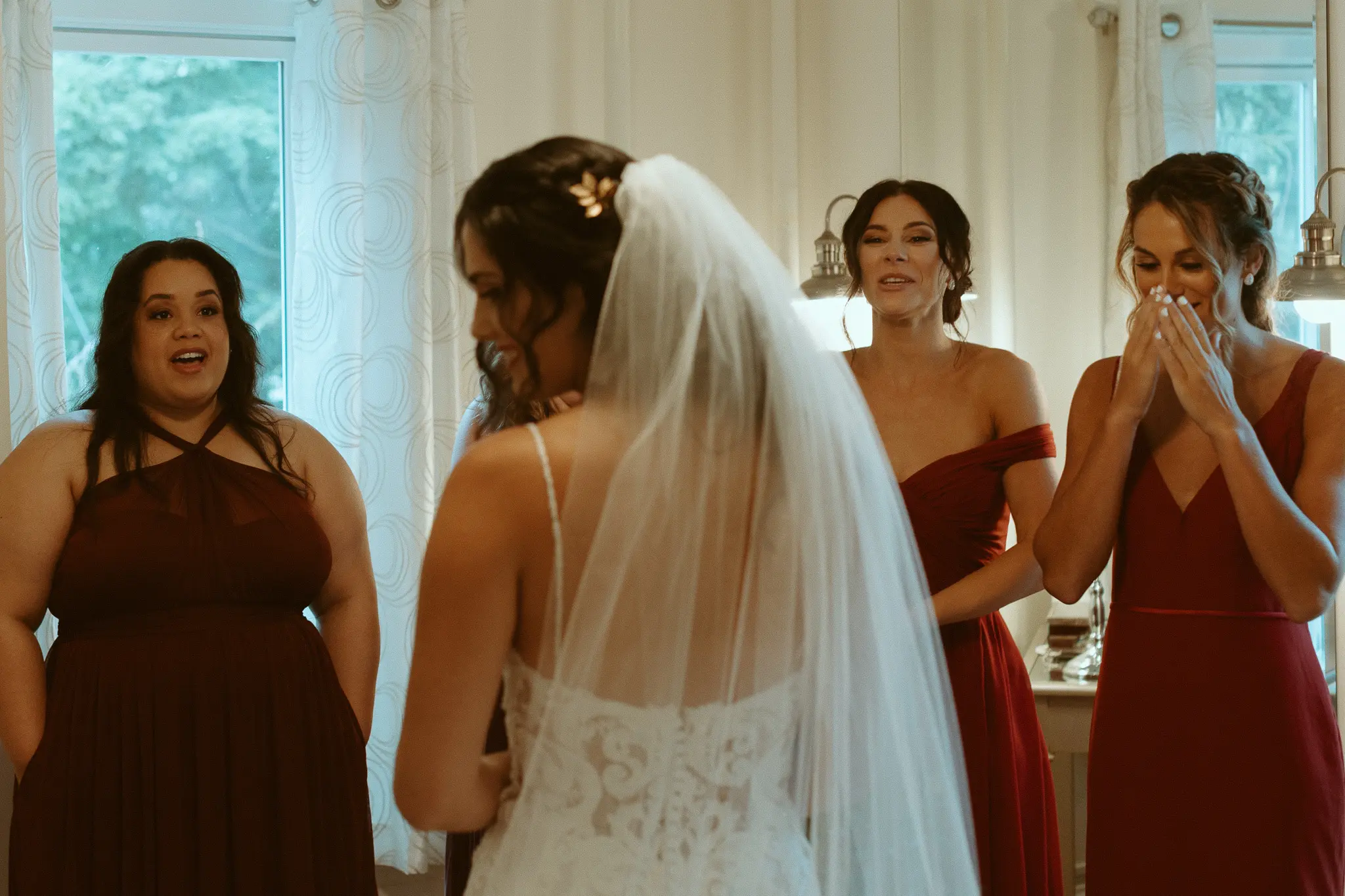 Bride with bridesmaids wearing lace sheath wedding dress.