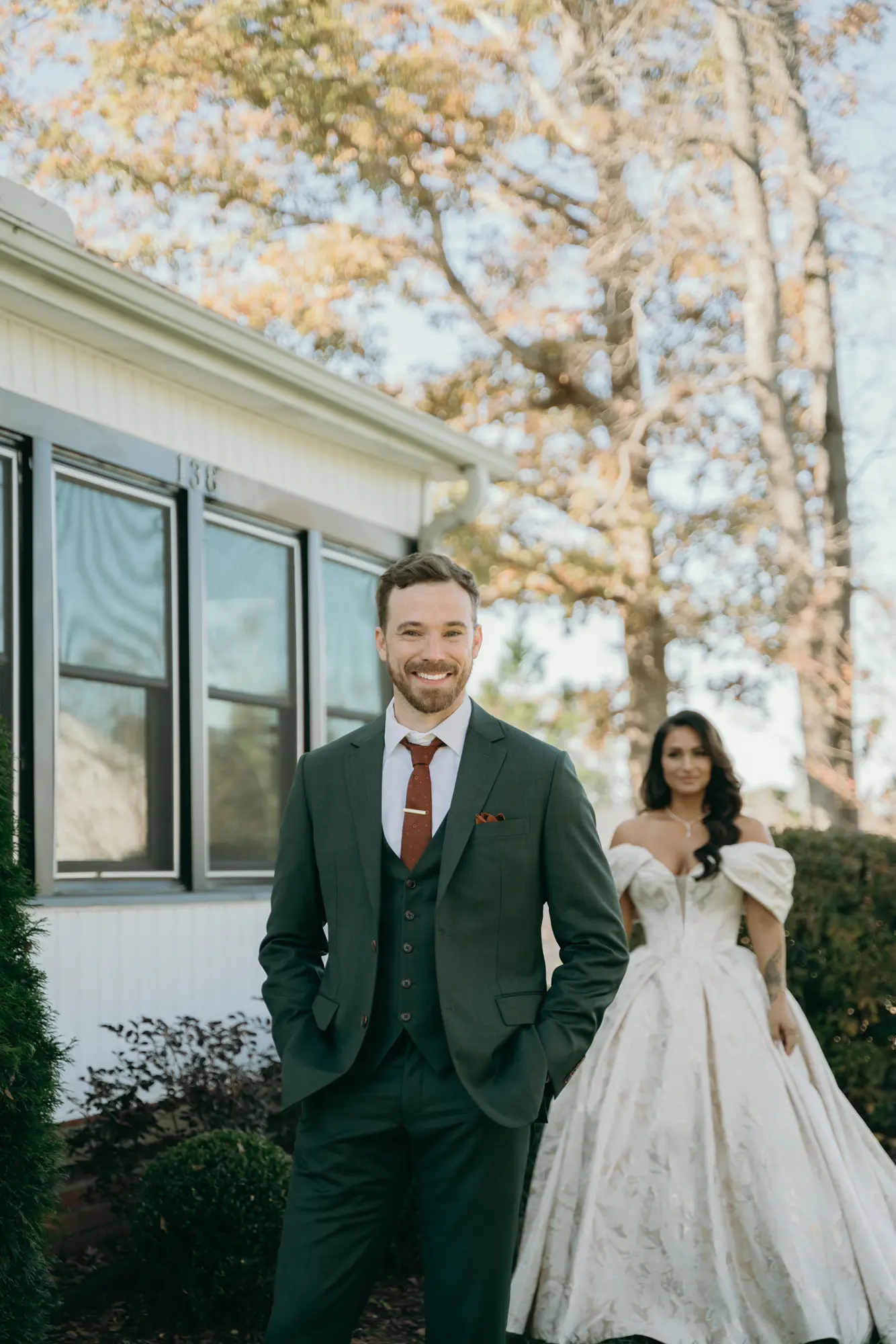Bride Wearing Floral Ballgown Wedding Dress Called Derrick Marie Standing Behind Groom