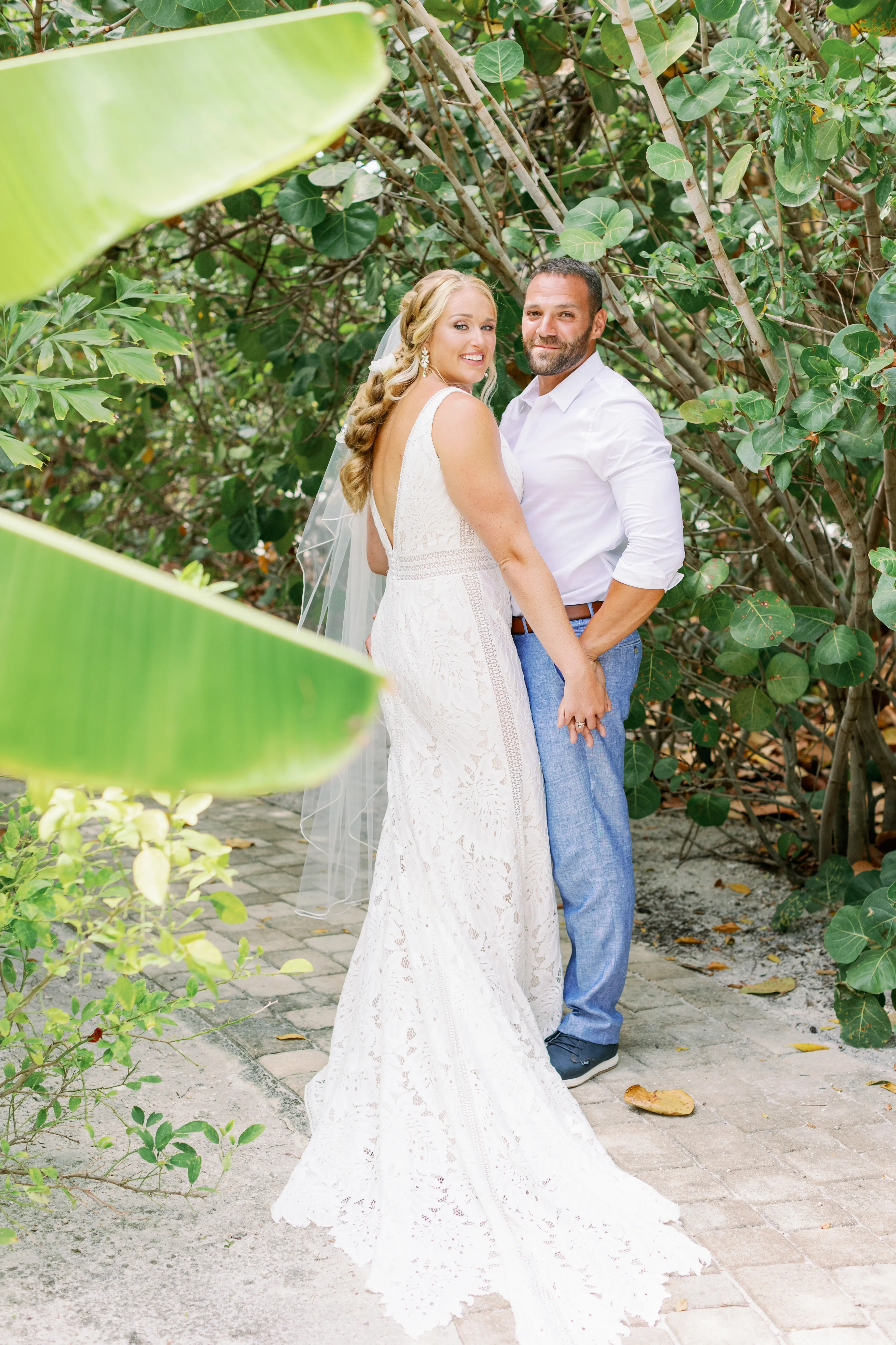 Bride wearing wedding dress called Burke, holding hands and standing closely to her groom.