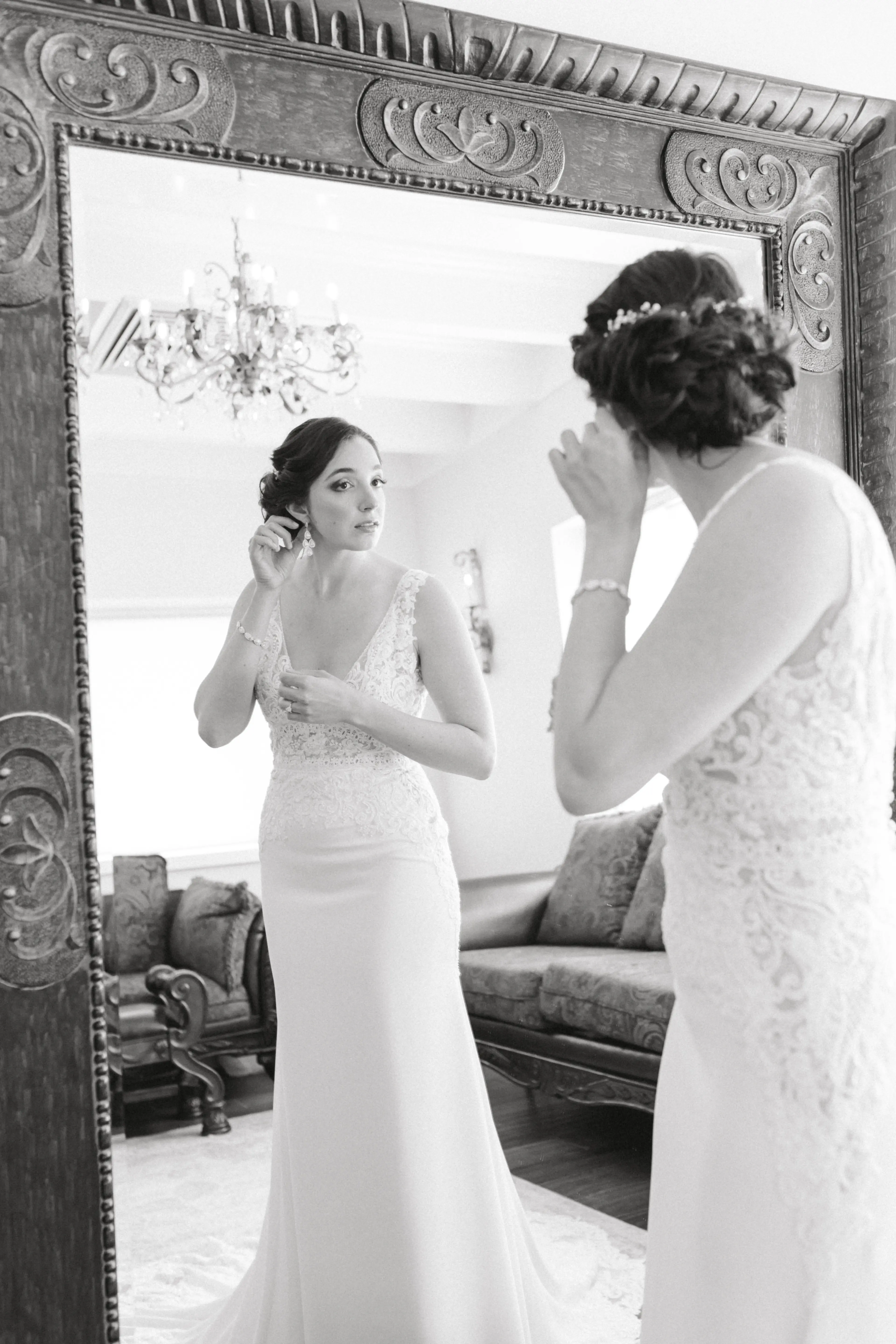 Bride looking in large mirror wearing wedding dress called Aidan.
