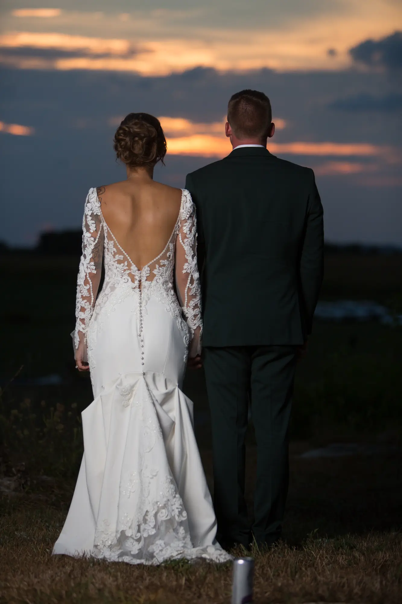 Bride Wearing Lace Mermaid Wedding Gown Called Nikki By Maggie Sottero With Groom Looking At The Sunset