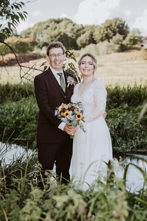 Bride In Long Sleeve Chiffon Wedding Dress Called Lorraine Dawn By Rebecca Ingram With Groom