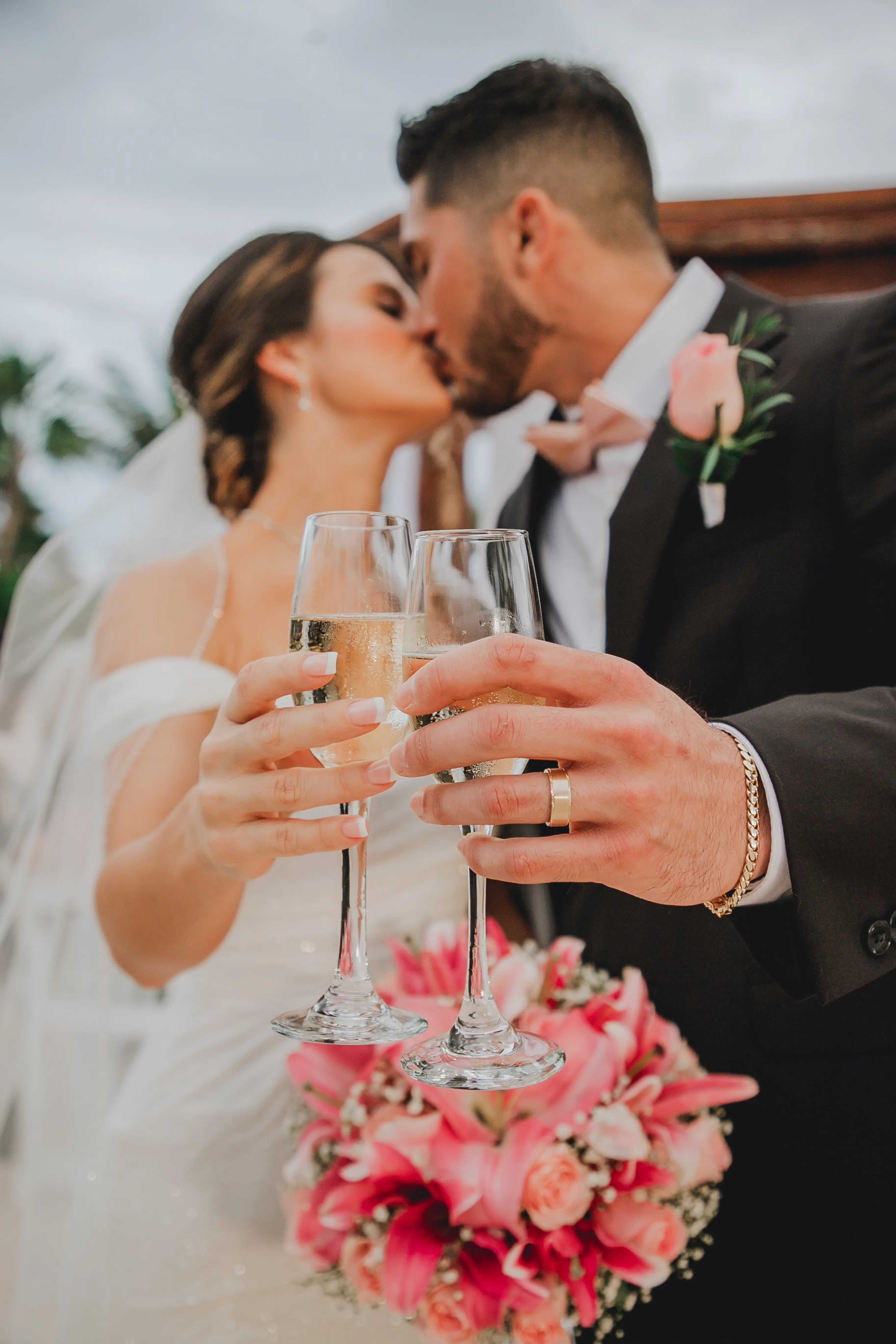 Bride Wearing Sparkly Fit And Flare Wedding Dress Called Anniston Lane By Maggie Sottero And Groom Clinking Champagne Glasses