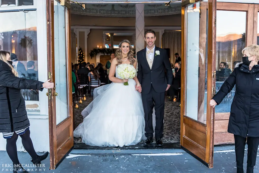 Bride with groom wearing strapless ballgown tulle wedding dress with sweetheart neckline indoors.