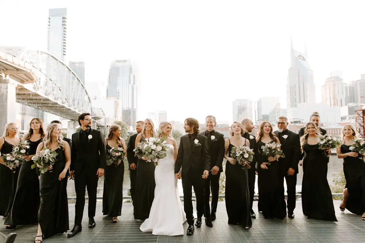 Groom With Bride And Bridal Party Wearing Unique Strapless Wedding Dress With Beautiful Back Bow Mitchell By Maggie Sottero