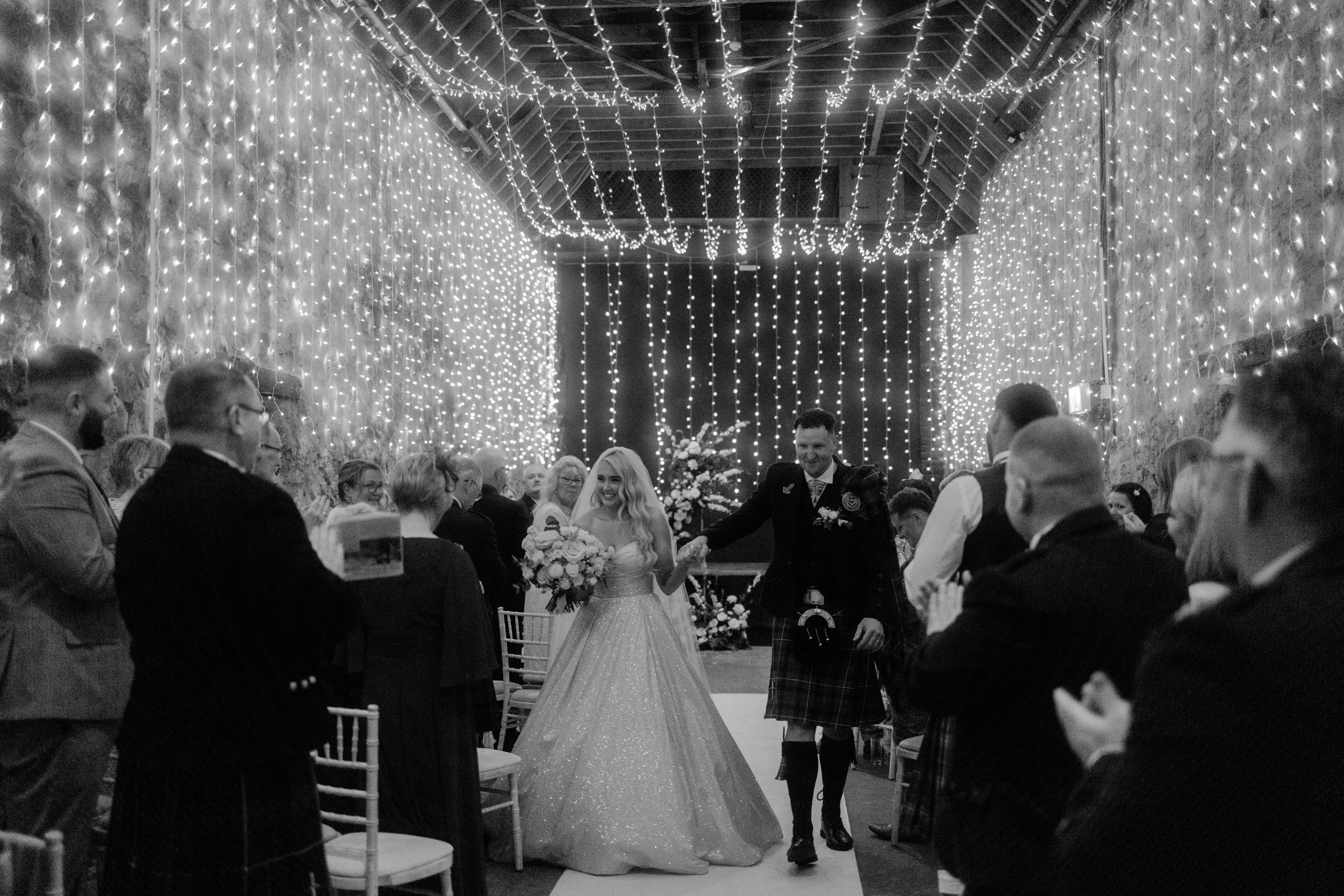 Bride Wearing Sparkly Aline Wedding Dress Called Anniston Leaving The Ceremony Holding Hands With Groom