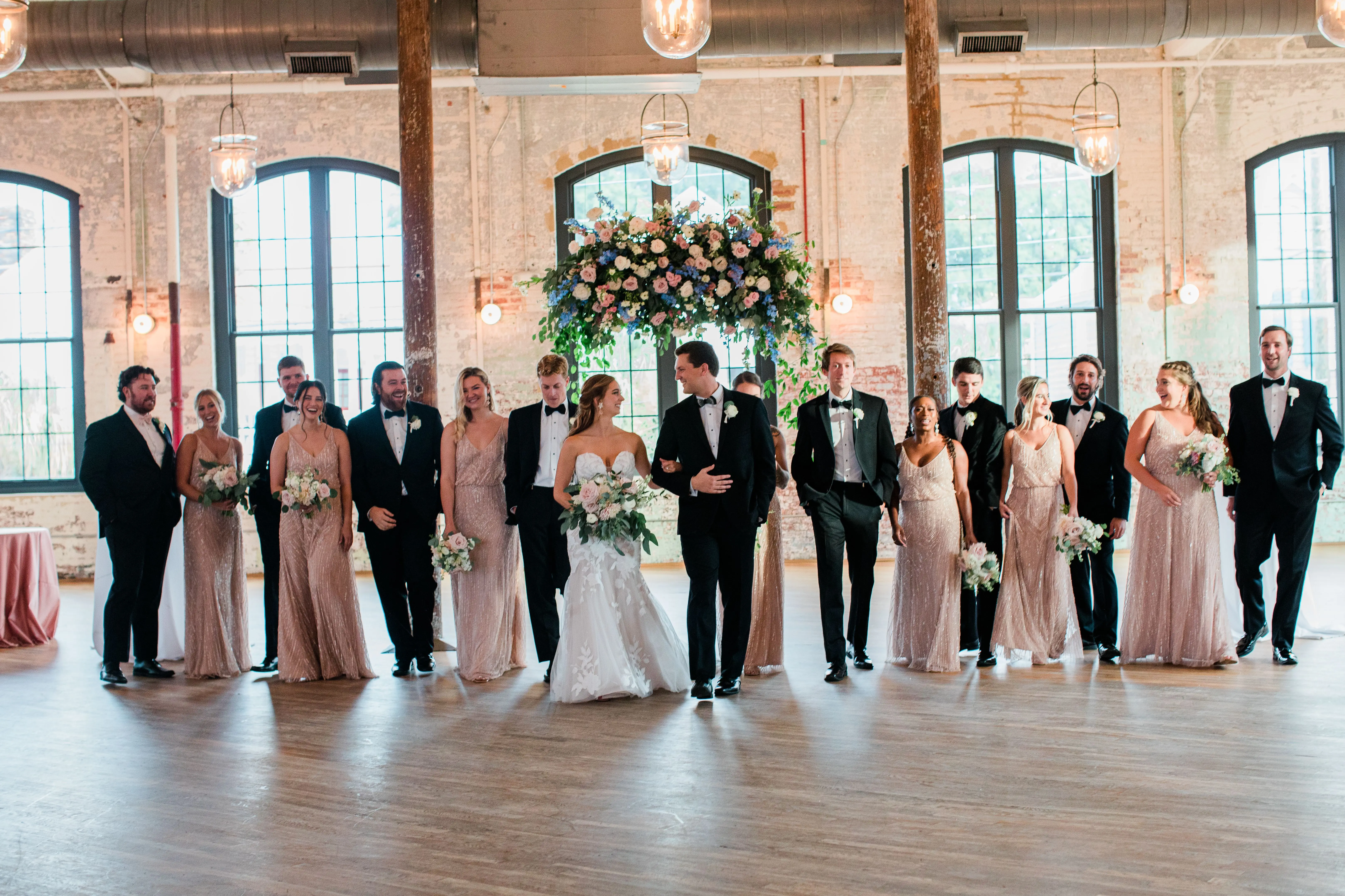 Bride with wedding party wearing strapless mermaid wedding dress with oversized lace