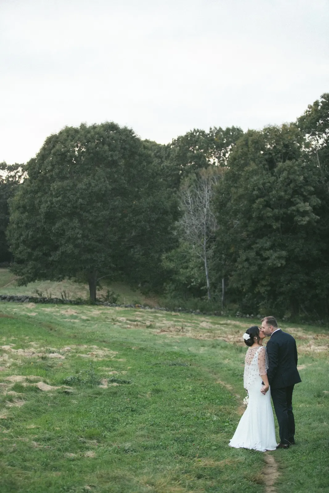 Groom and Bride Wearing Minimalist Crepe Fit-and-Flare Wedding Dress Called Fernanda by Maggie Sottero