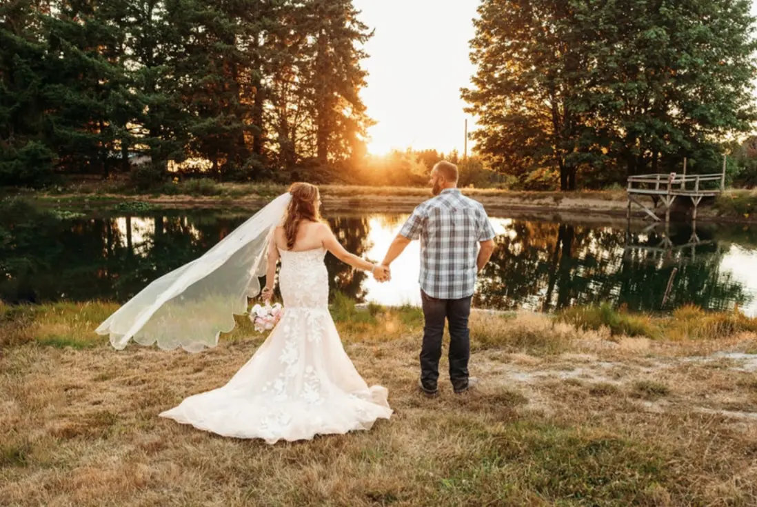 Bride wearing Hattie wedding dress by Rebecca Ingram holding hands with her husband