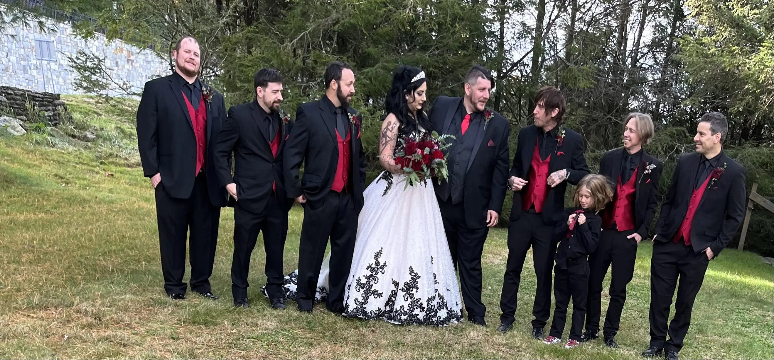 Bride wearing Black Lace Ballgown Wedding Dress called Tristyn by Maggie Sottero, groom, and groomsmen in black and red tuxedos