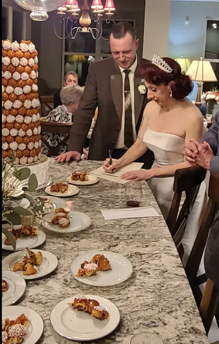 Bride Wearing Classic Simple Wedding Dress Called Mitchell By Maggie Sottero And Groom Signing Papers