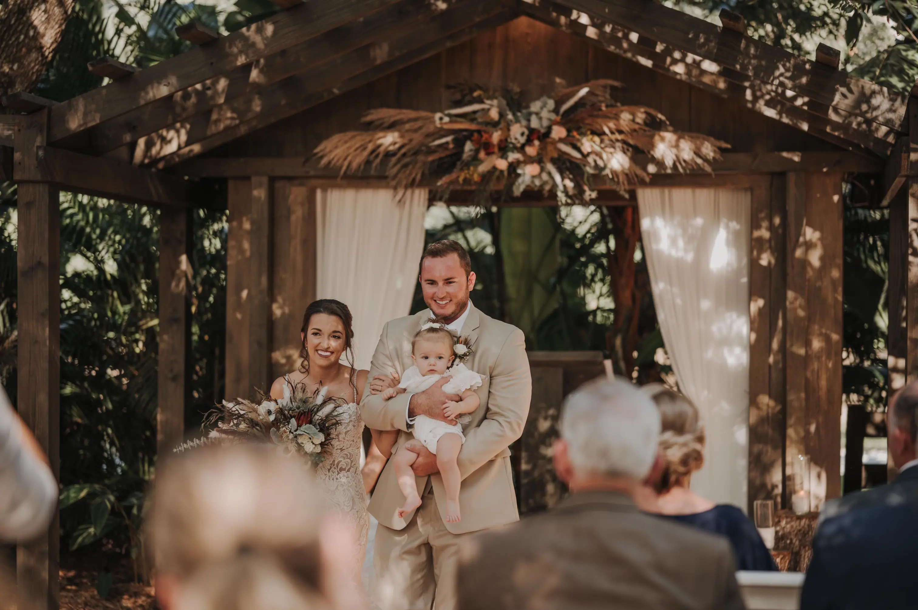Groom holding a baby and Bride Wearing Lace Mermaid Wedding Gown Called Fiona by Maggie Sottero